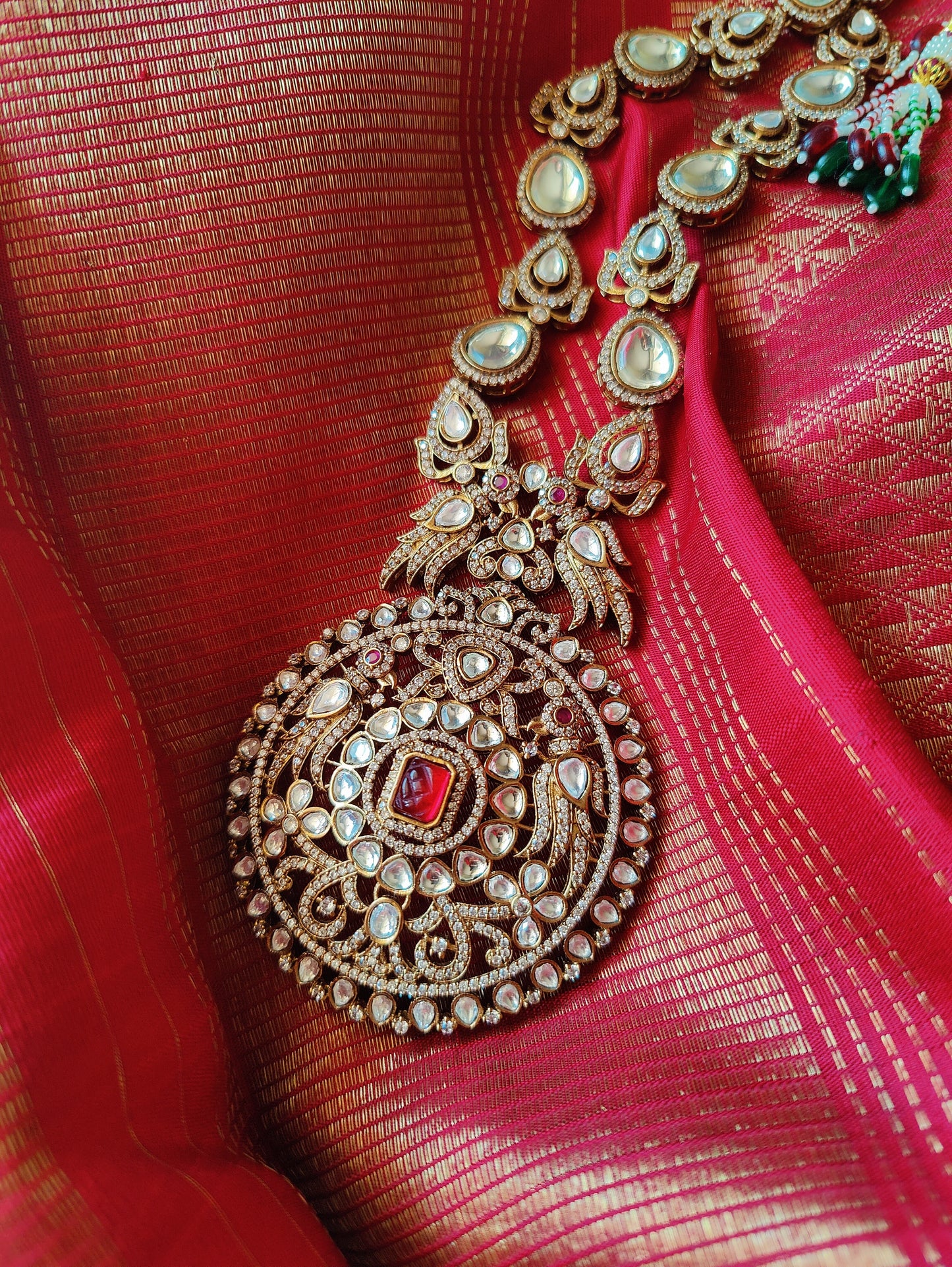 Kundan necklace and earrings set with a statement centerpiece flanked by stone studded peacocks