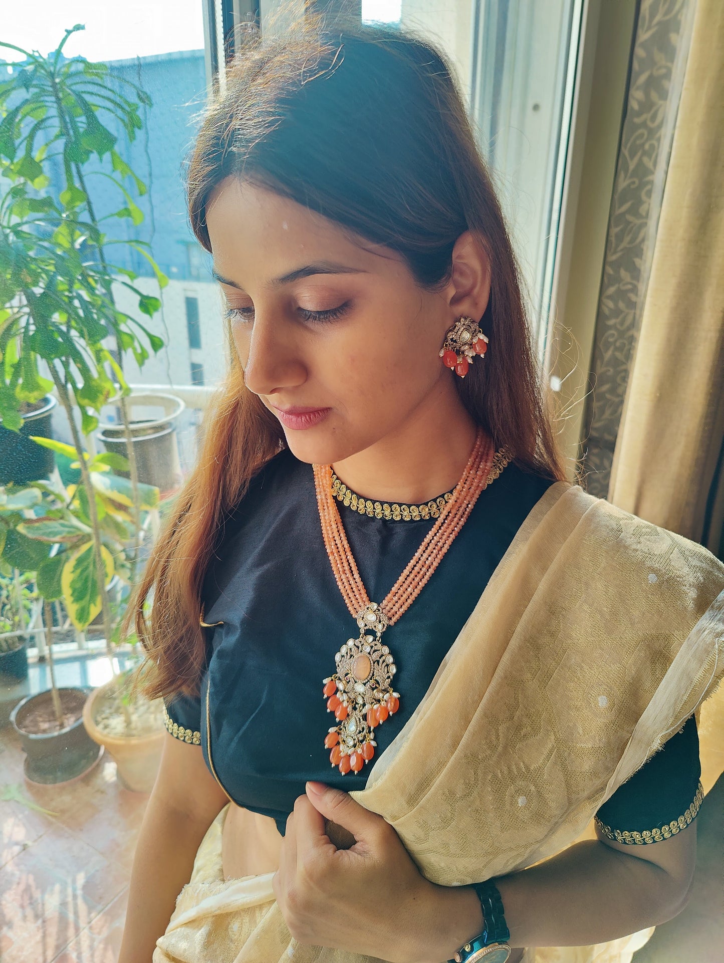 Set in gajari/ peach stone strings with a peacock motif pendant