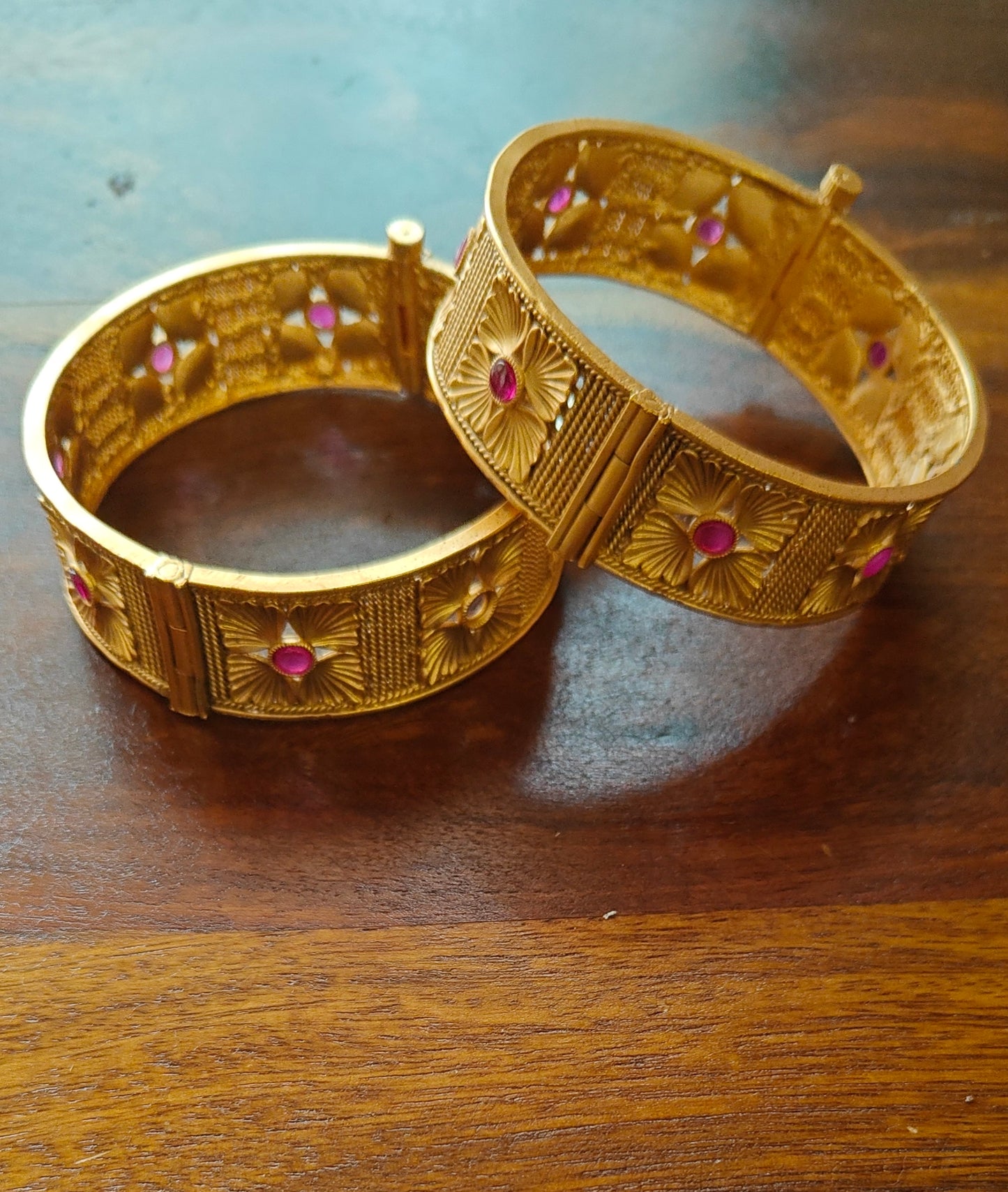 Golden karas with flowers with red stone in repeat pattern