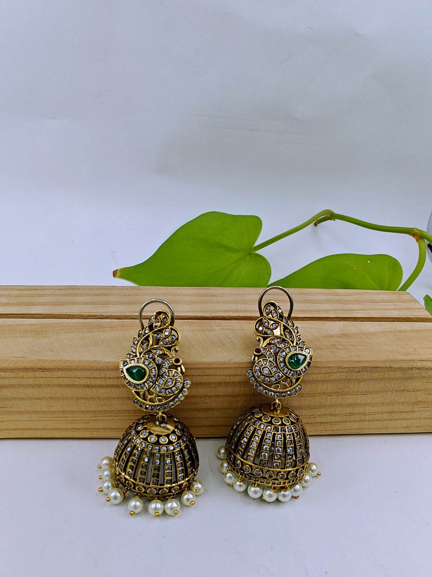 Antique jhumkis(earrings) with pearl hangings and peacock design on stud with green stone