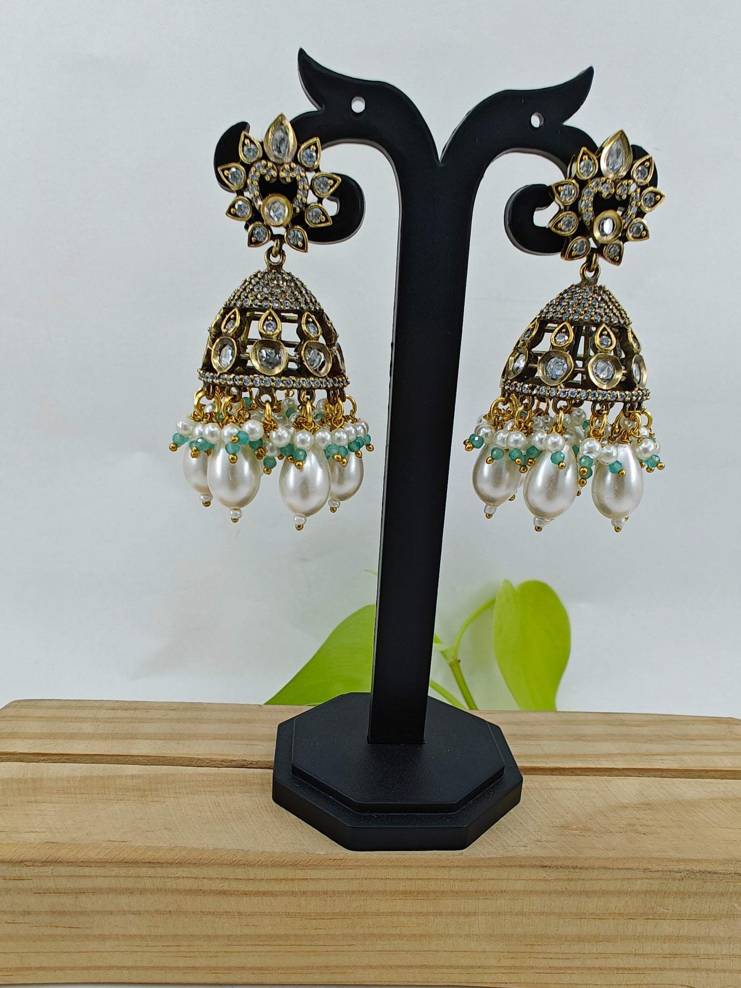 Set in antique finish with a mint stone pendant with kundan and CZ on pearl strands, matching jhumkas(earrings)
