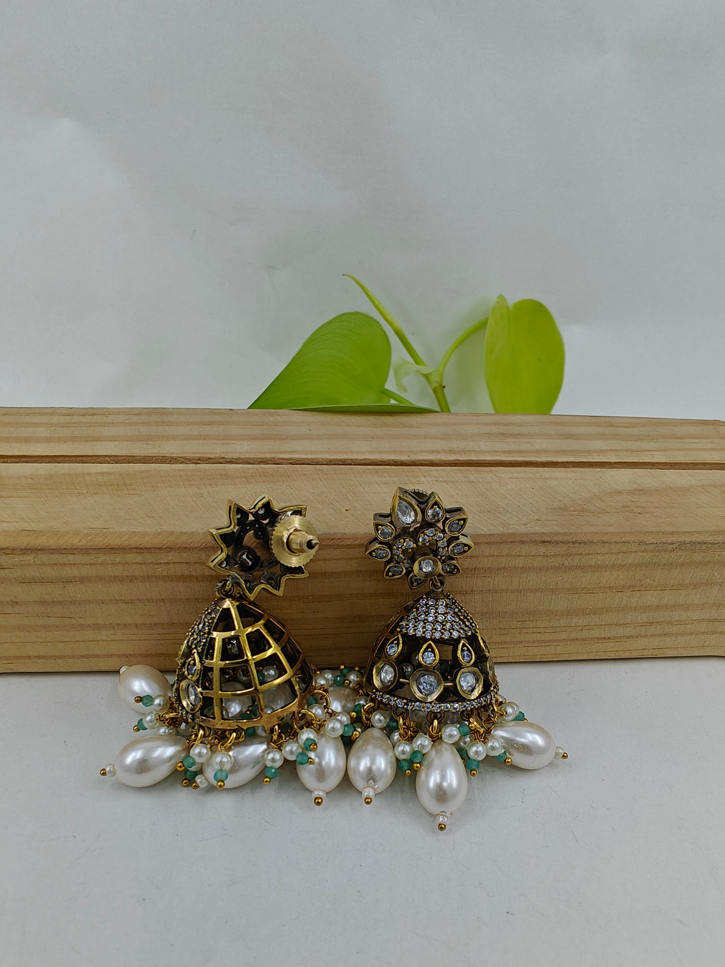 Set in antique finish with a mint stone pendant with kundan and CZ on pearl strands, matching jhumkas(earrings)