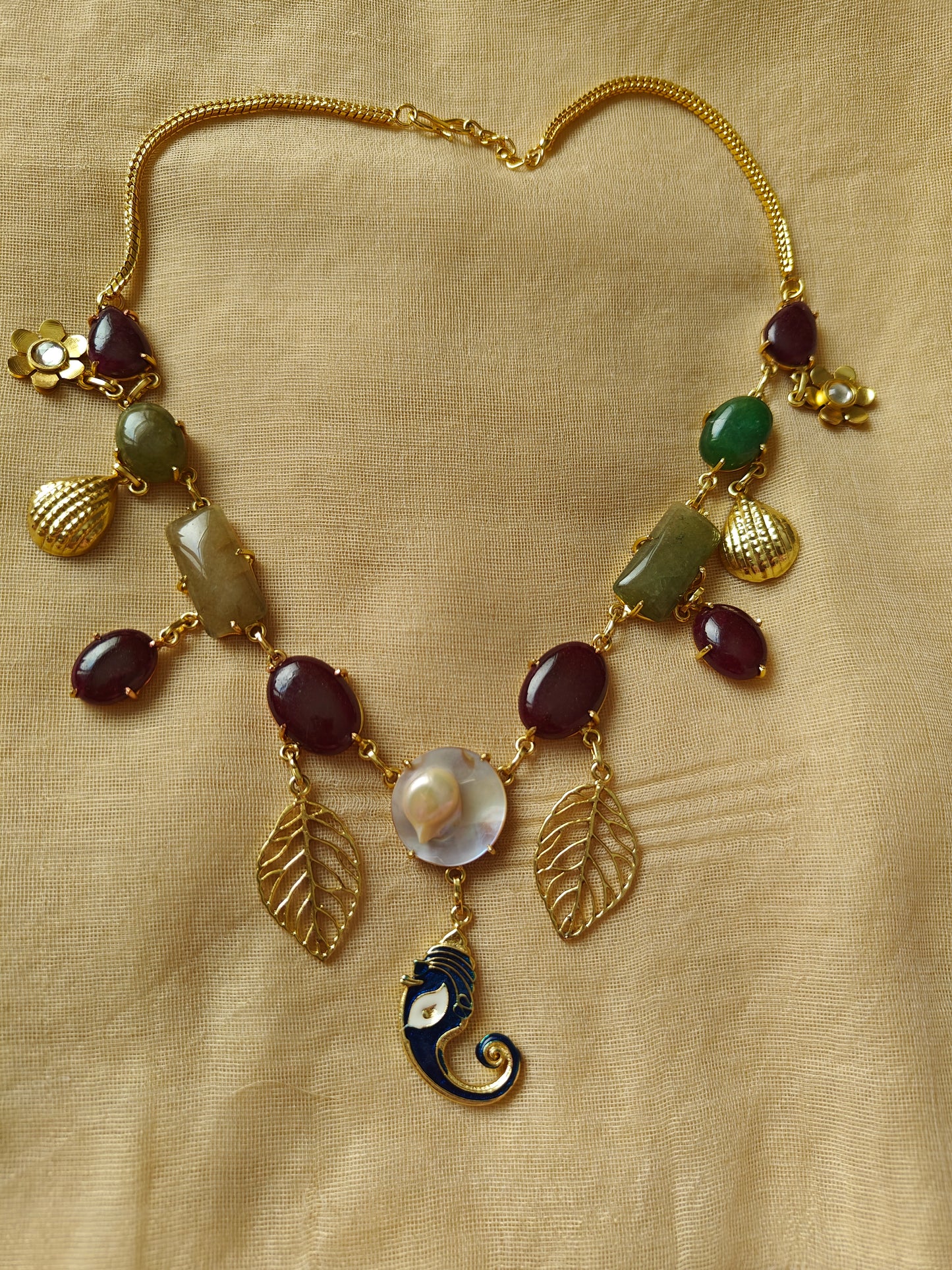 Necklace in gold finish with stones and different hangings