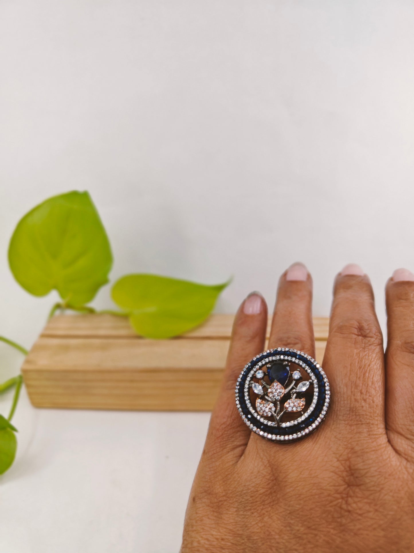 Platinum finish ring with sapphire flower with CZ leaves