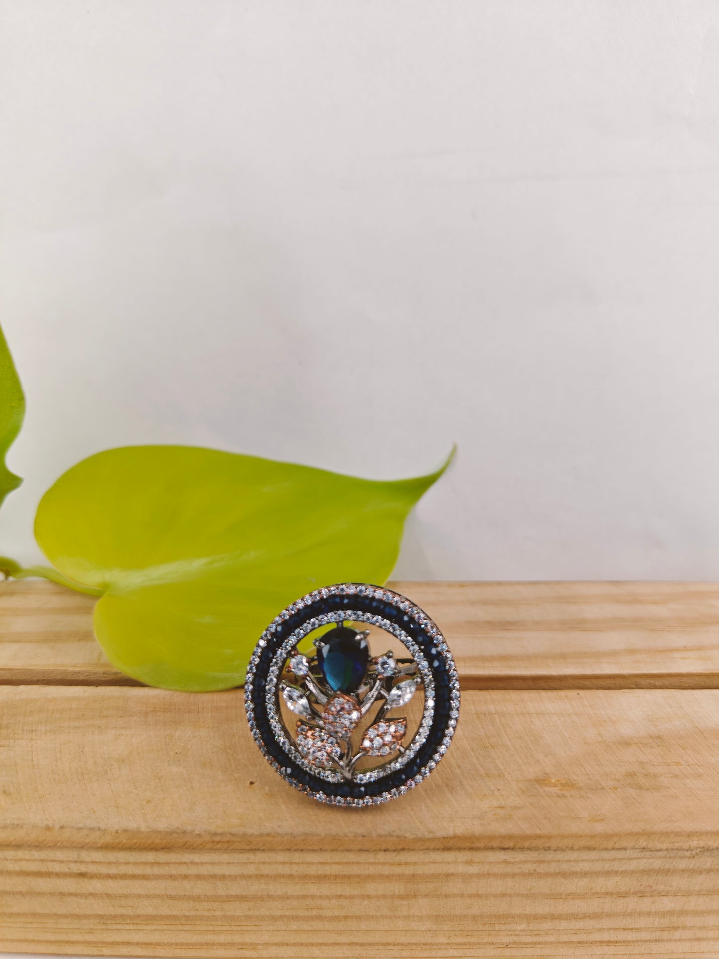 Platinum finish ring with sapphire flower with CZ leaves