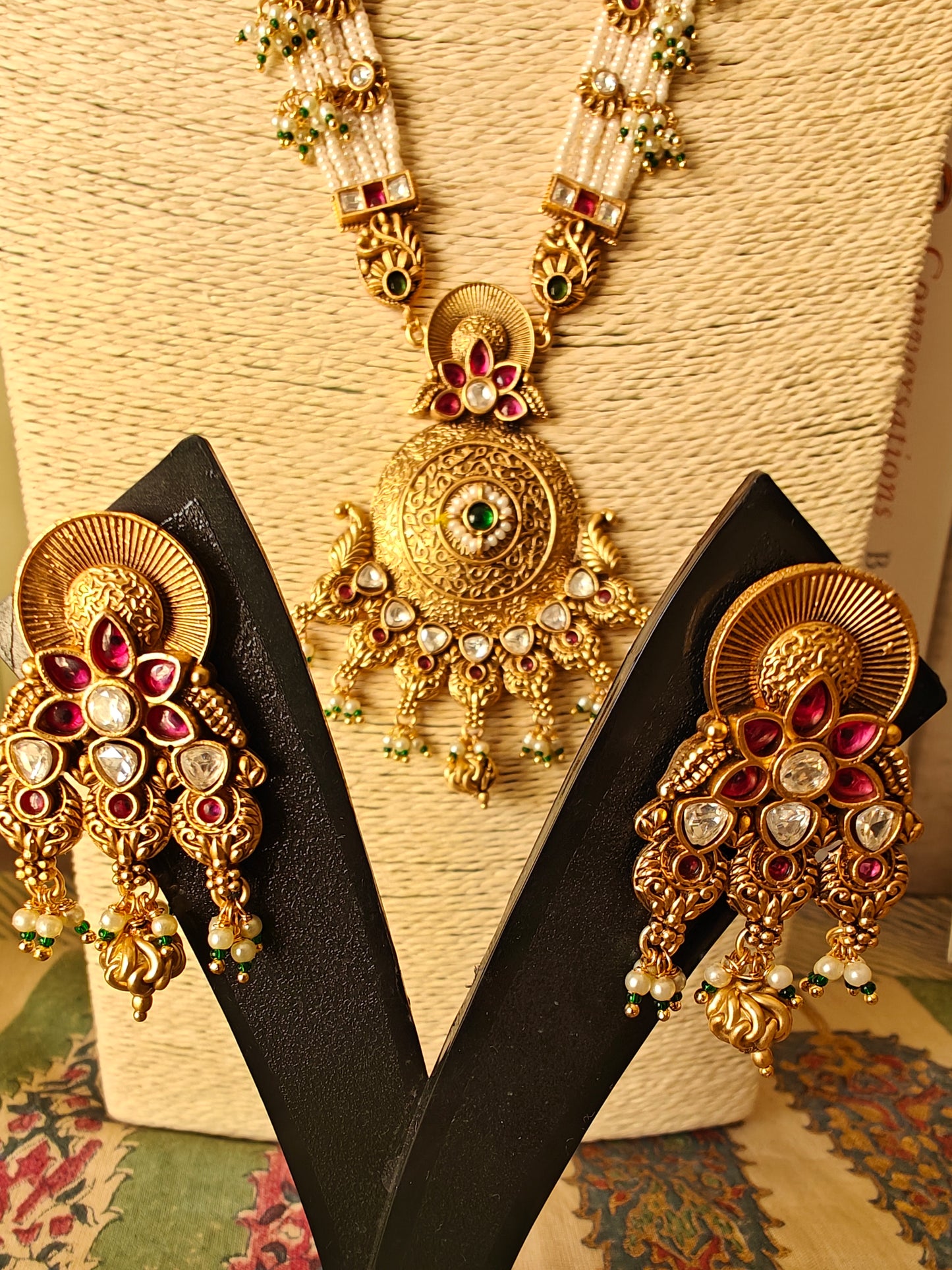 A kundan and pearl work set with a gold finish pendant on poth pearl strings with pachi kundan work