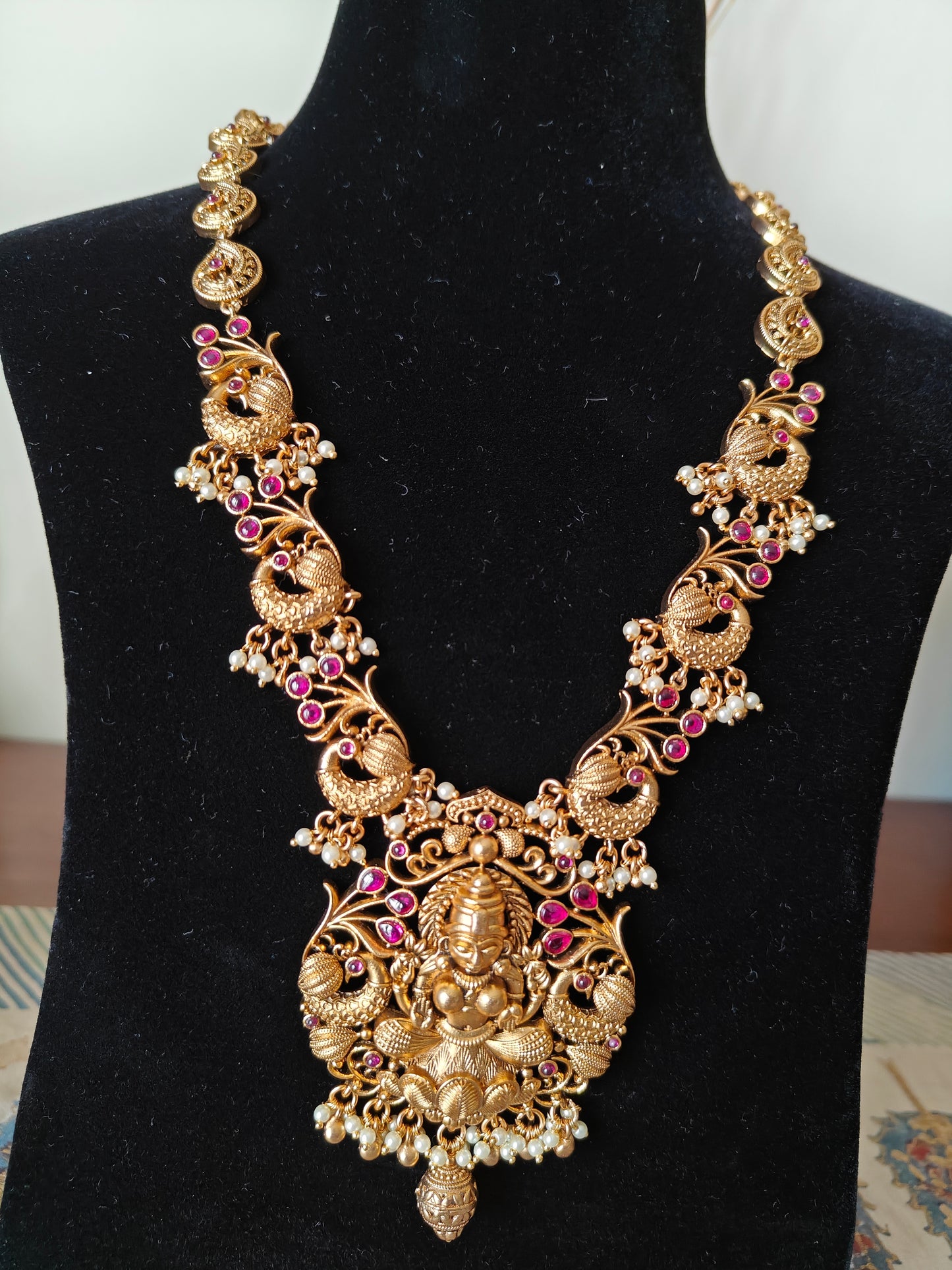 Padmavati Temple set in a gold finish with a Lakshmi pendant, peacock motif all around necklace