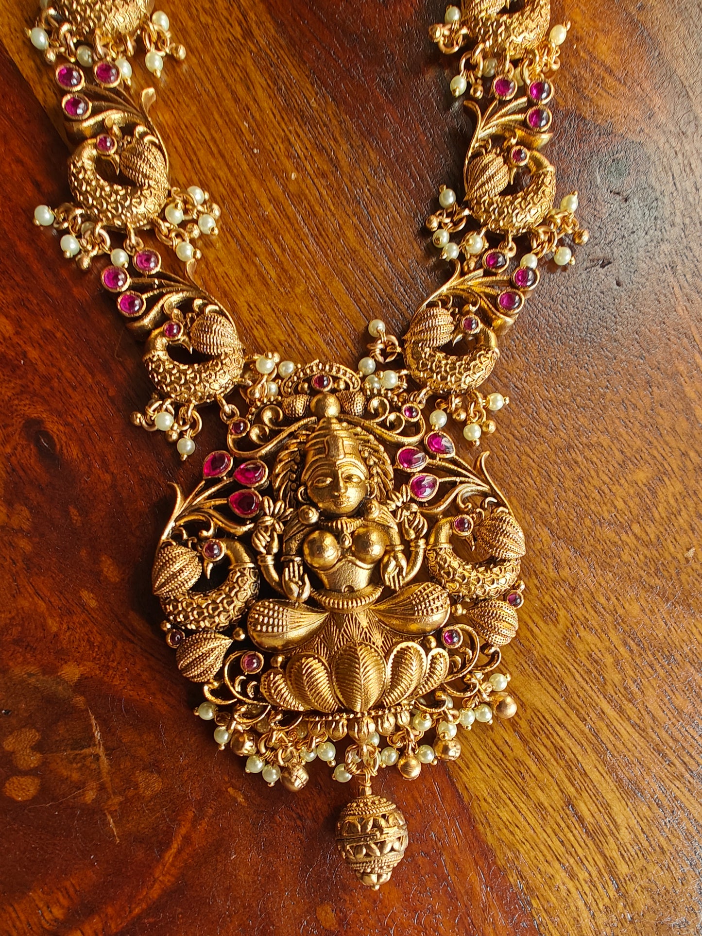 Padmavati Temple set in a gold finish with a Lakshmi pendant, peacock motif all around necklace