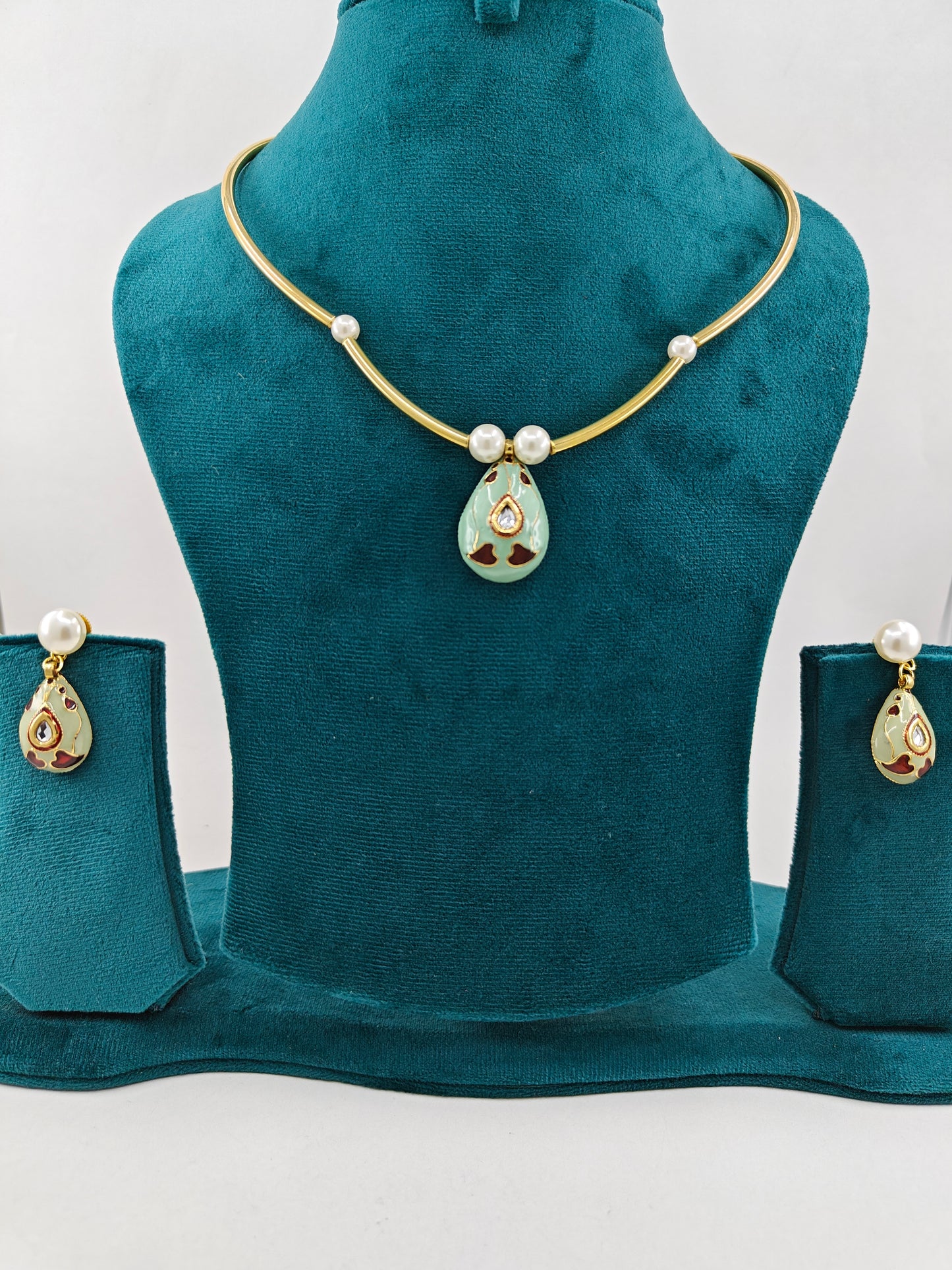Golden pipe hasli reversible set with meenakari work with kundan on one side and pearls and stone on the other