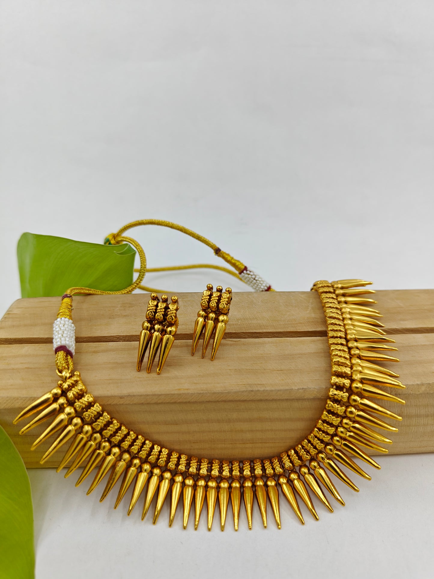 Gold finish set with spikes on the necklace and matching studs