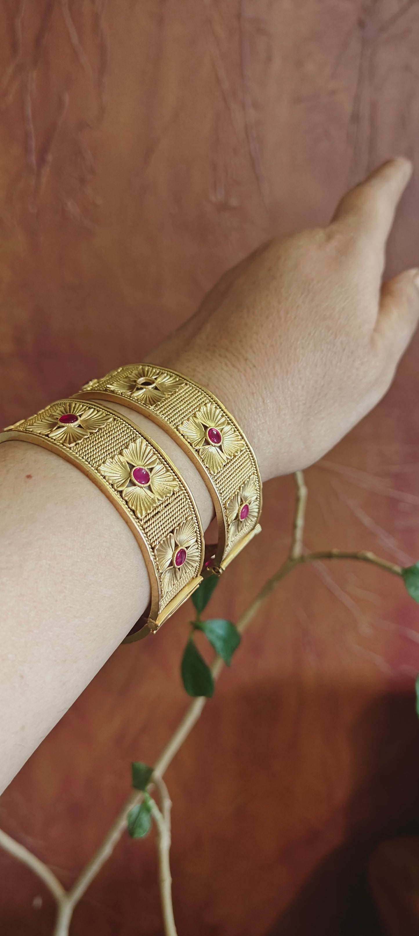 Golden karas with flowers with red stone in repeat pattern