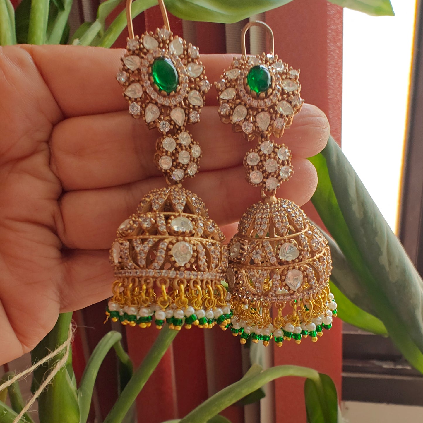 Long jhumkis with moissanite and emerald green stone
