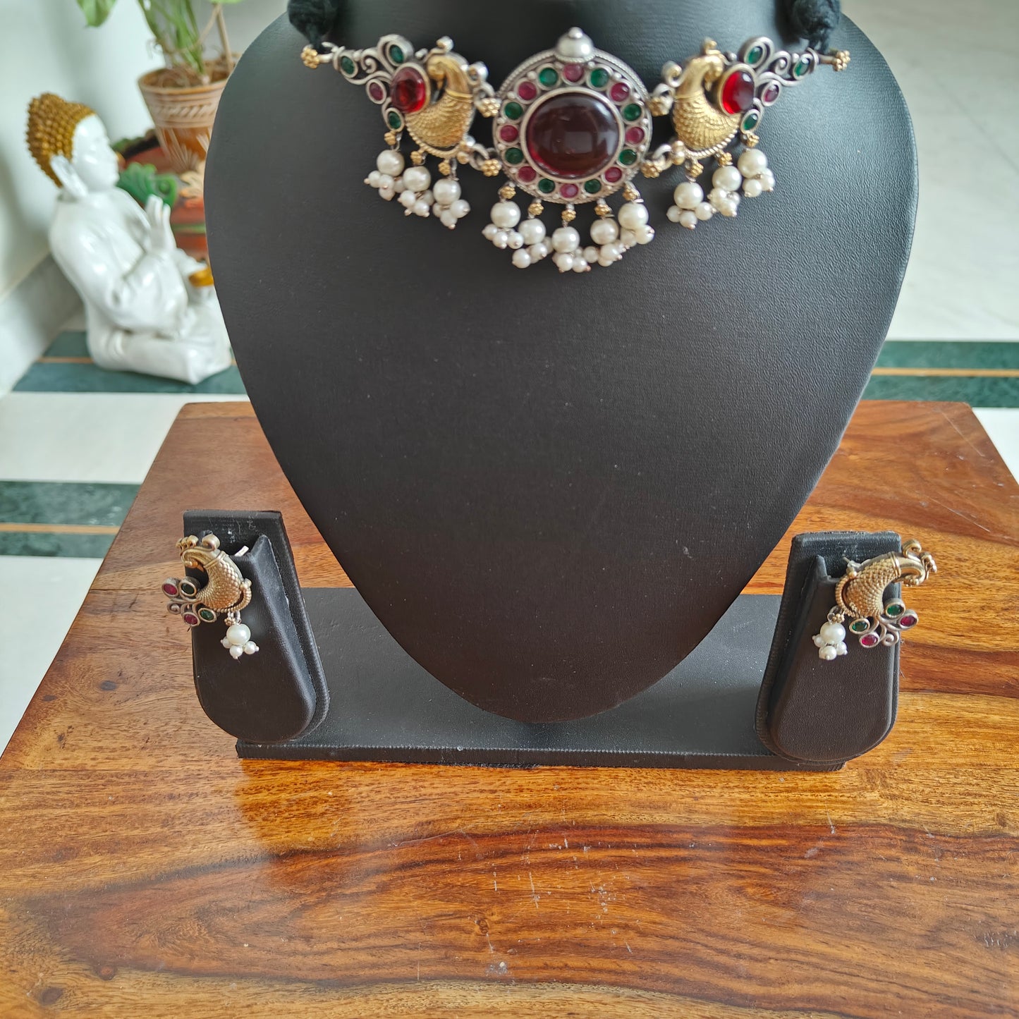 Dual tone choker set with a stone central piece and peacocks