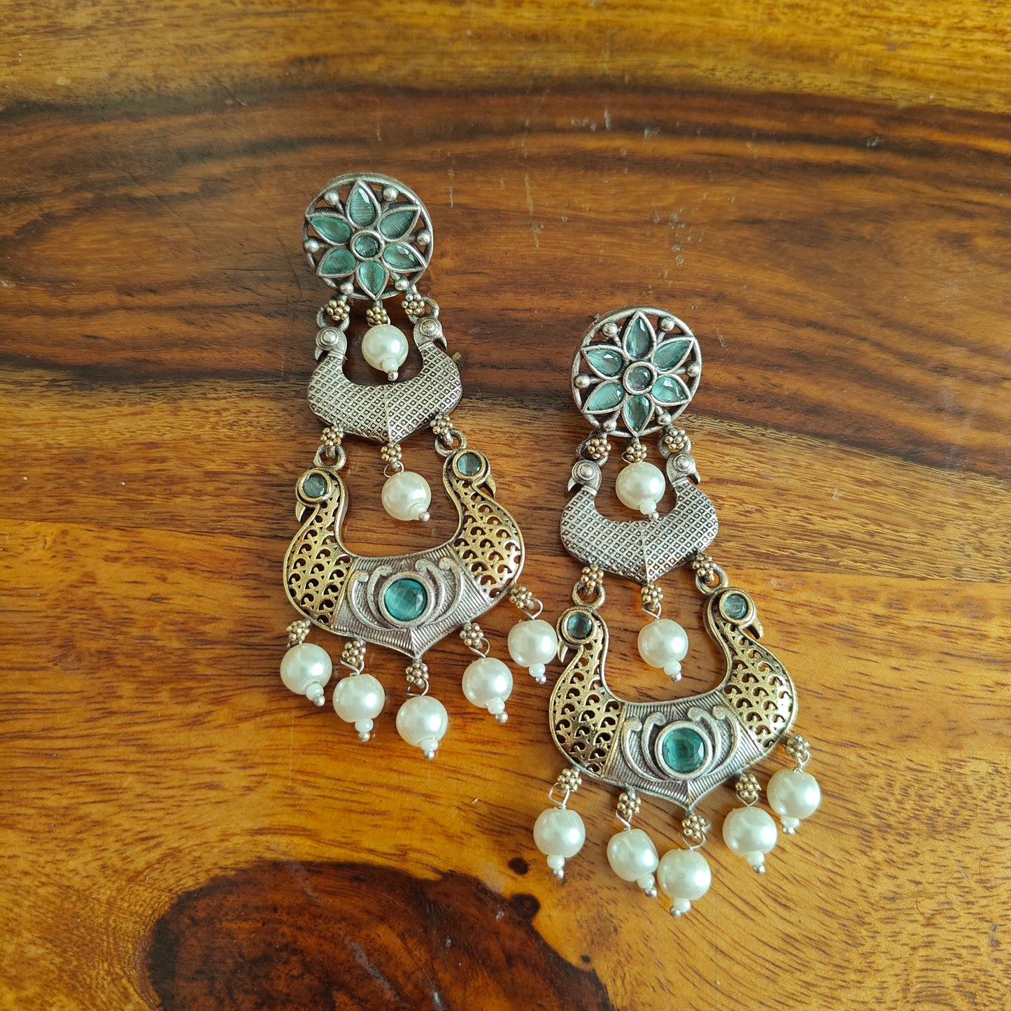 Dual tone earrings with peacocks and stone