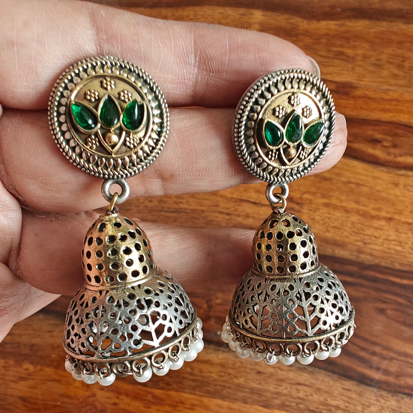 Dual tone earrings with a dome jhumki and green stone