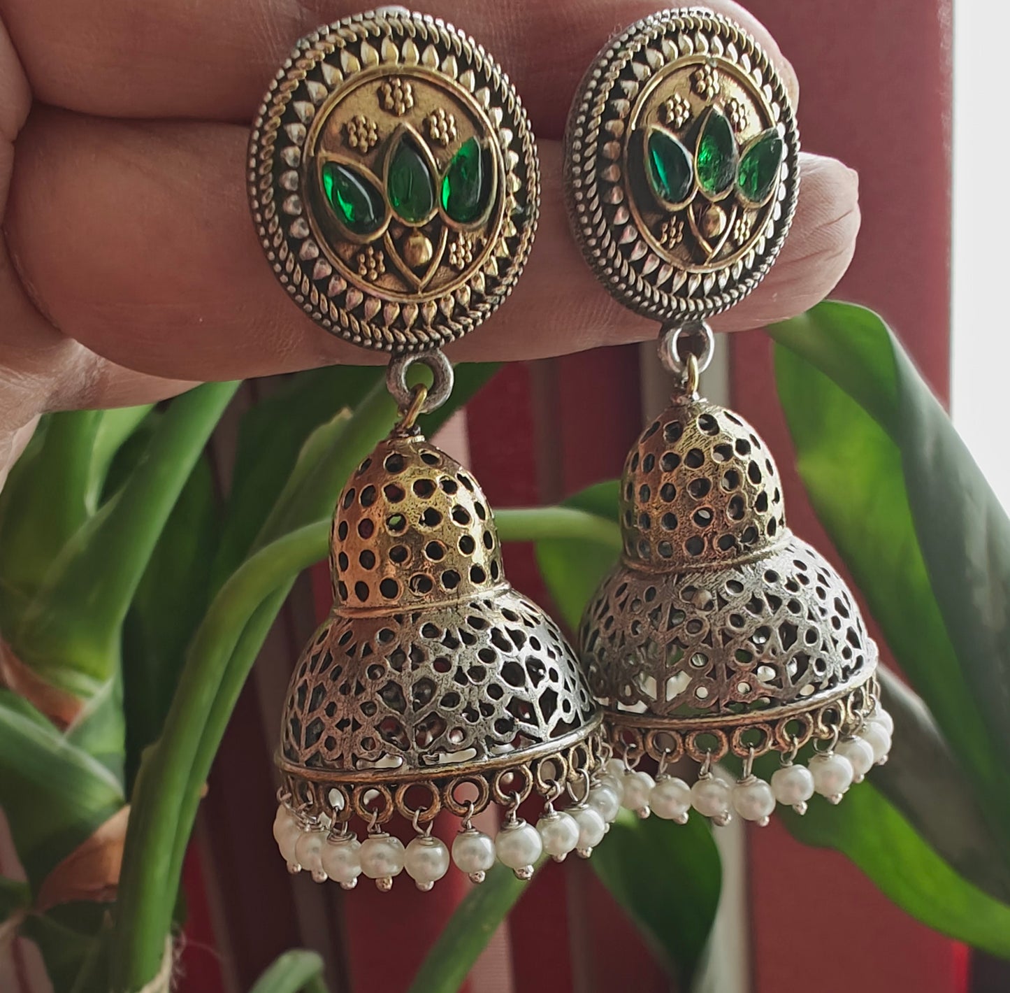 Dual tone earrings with a dome jhumki and green stone