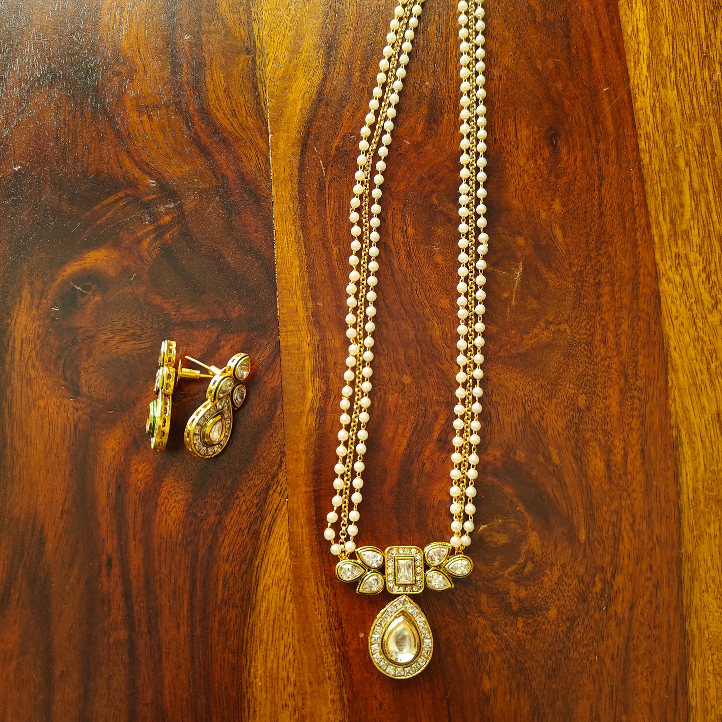 Pearl and gold chain holding kundan and tone pendant