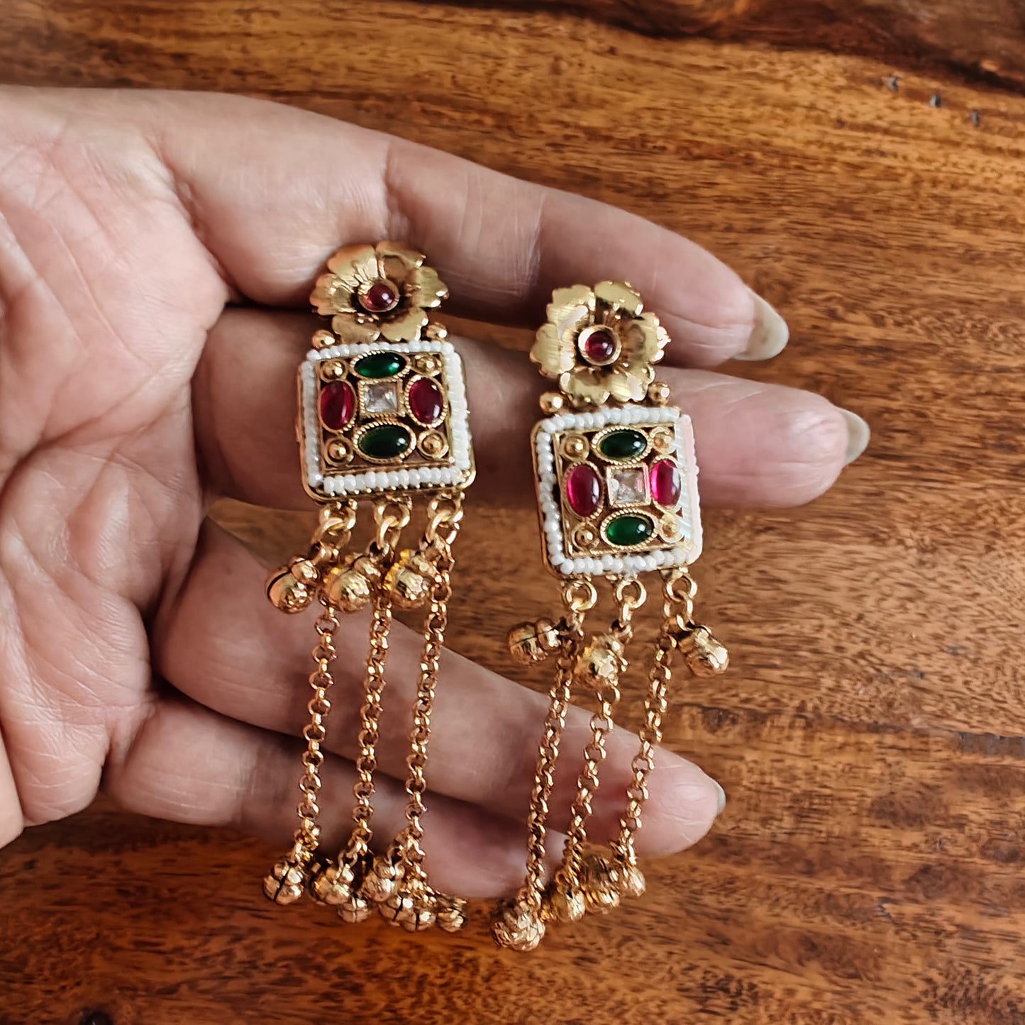 Gold earrings with hanging chains and gold balls below square with pearls and stone