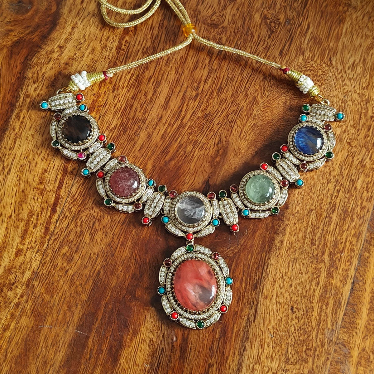Swaha set with multicolour stones, pendant below with navratan highlights.