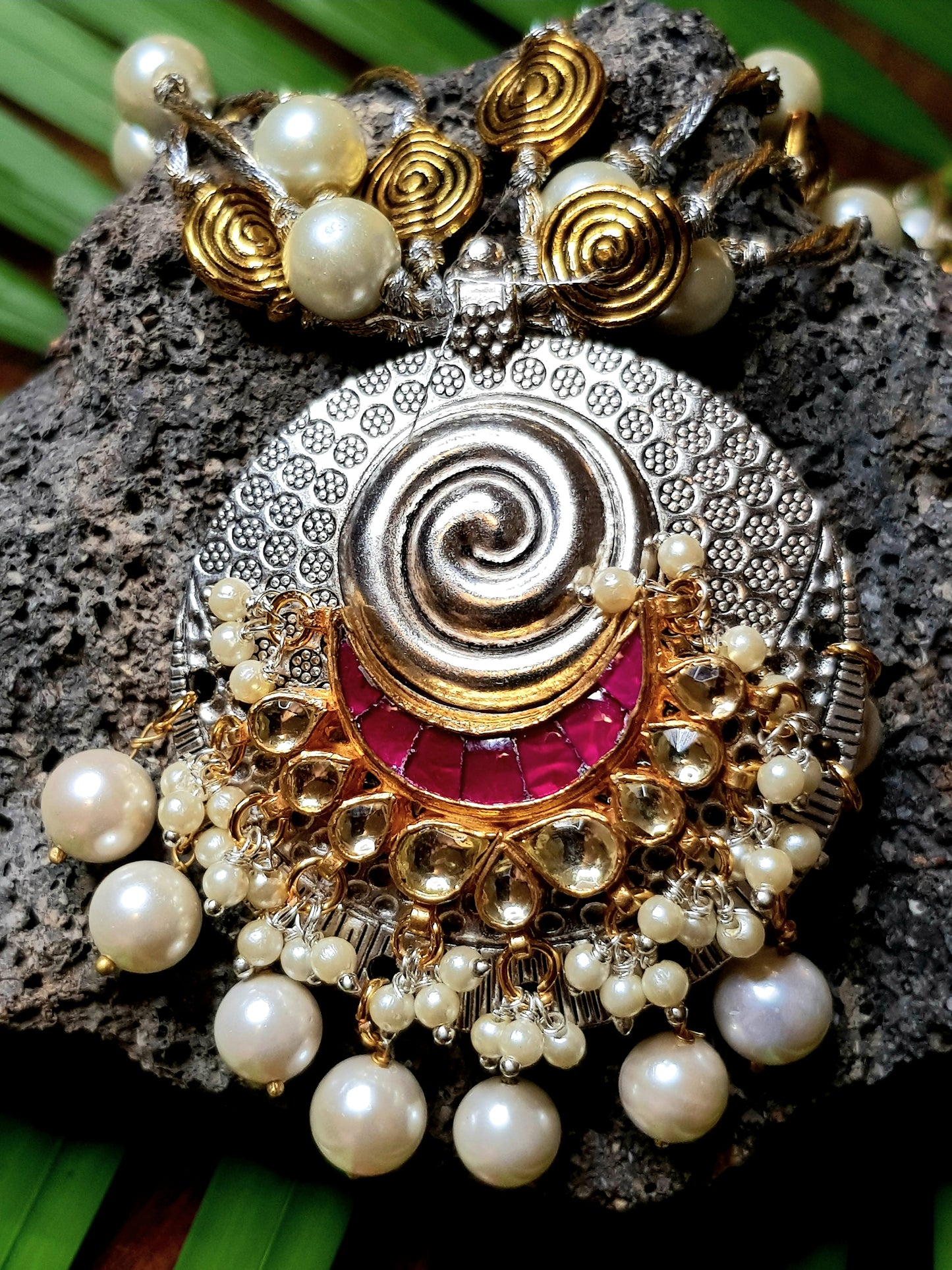 A funky set in silver finish with pearls and golden coils on multiple strings ,a pendant with red/green stone,kundan and pearls,Big earring/jhumkis