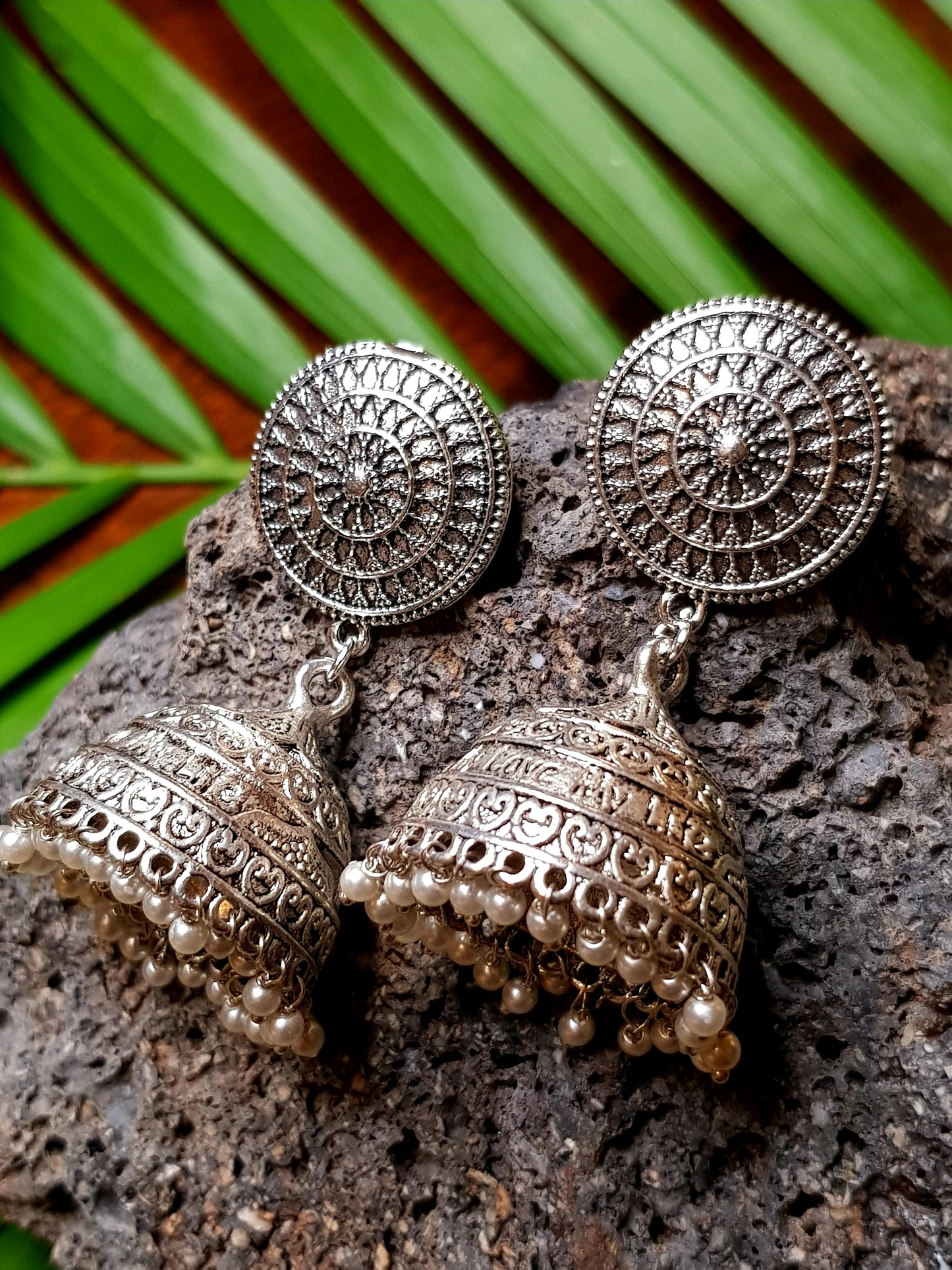 A funky set in silver finish with pearls and golden coils on multiple strings ,a pendant with red/green stone,kundan and pearls,Big earring/jhumkis
