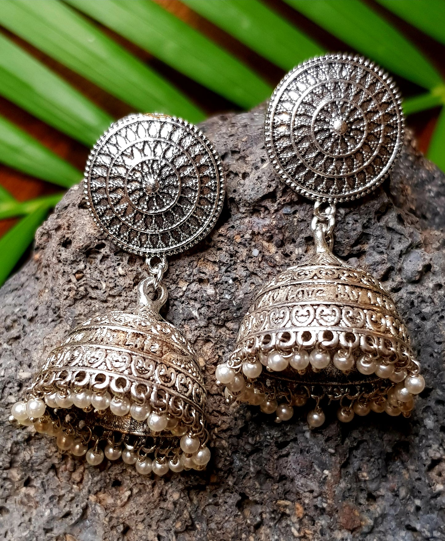 A funky set in silver finish with pearls and golden coils on multiple strings ,a pendant with red/green stone,kundan and pearls,Big earring/jhumkis