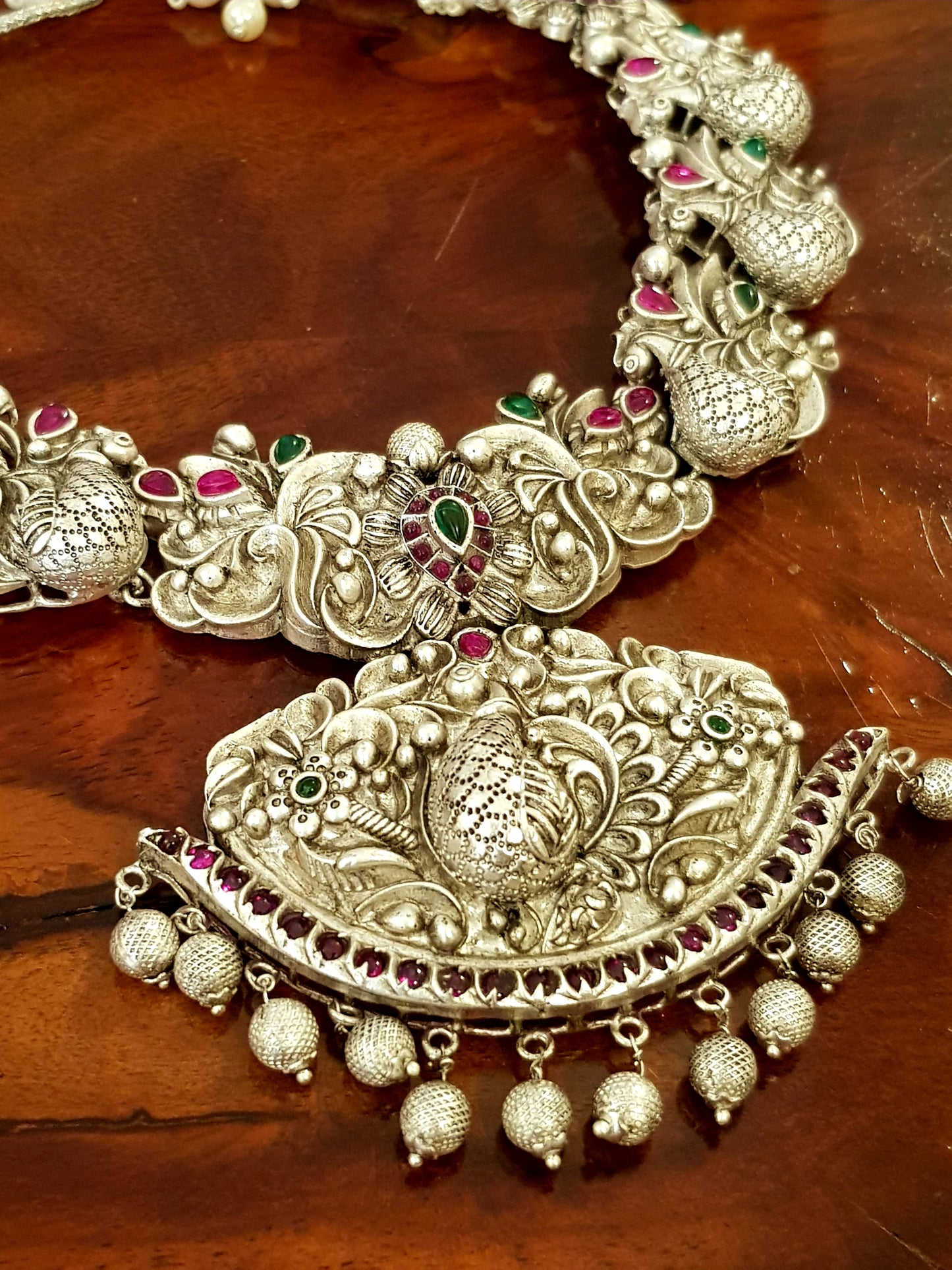 Silver finish temple jewelry set, necklace with peacock motif, green-red stones inlay, matching jhumkas (earrings)
