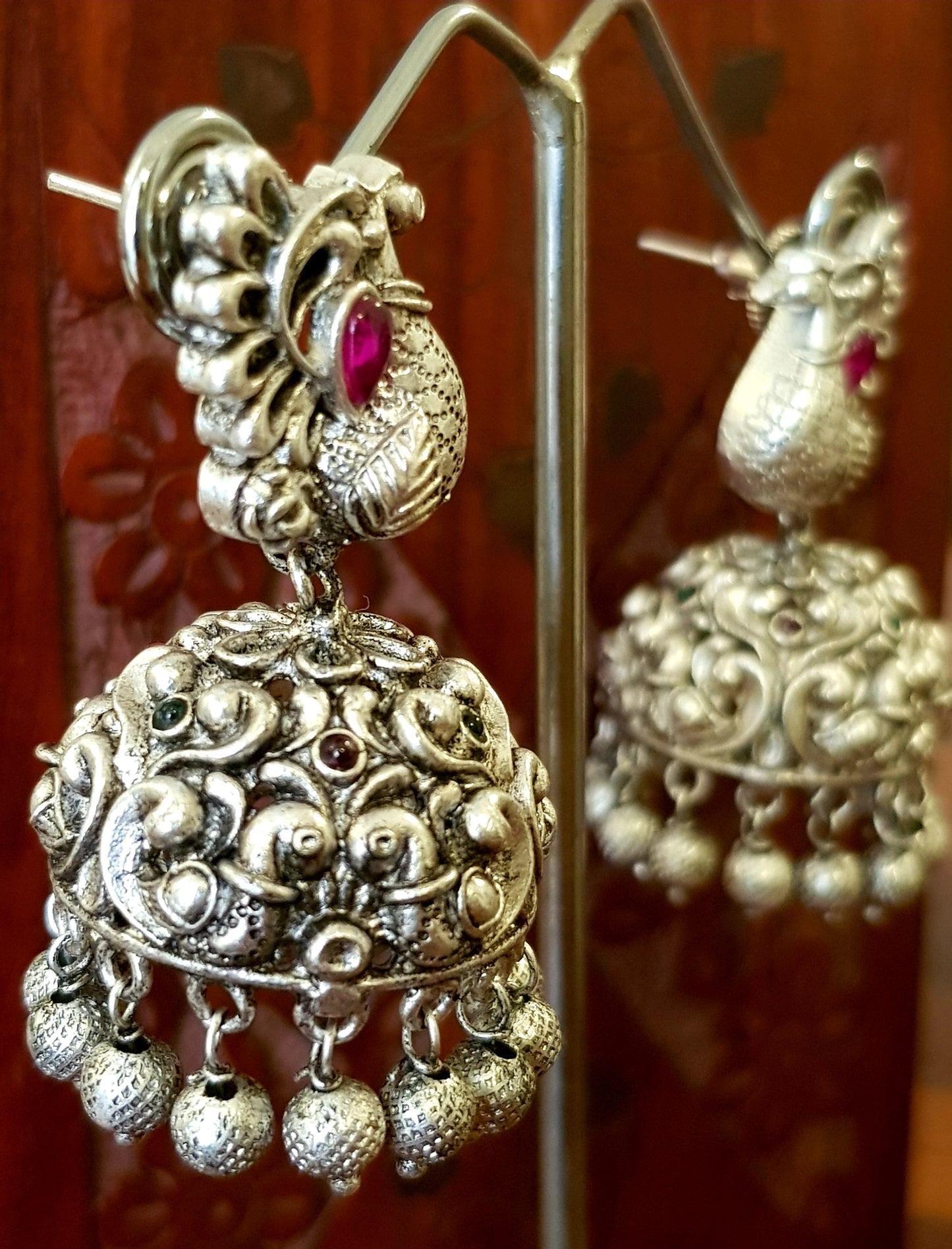 Silver finish temple jewelry set, necklace with peacock motif, green-red stones inlay, matching jhumkas (earrings)