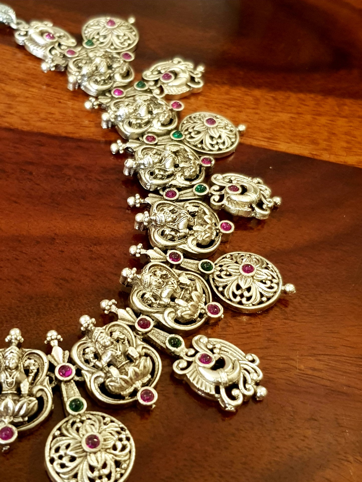 Silver finish temple jewelry set, necklace with Lakshmi motif, green-red stones inlay, matching jhumkas (earrings)