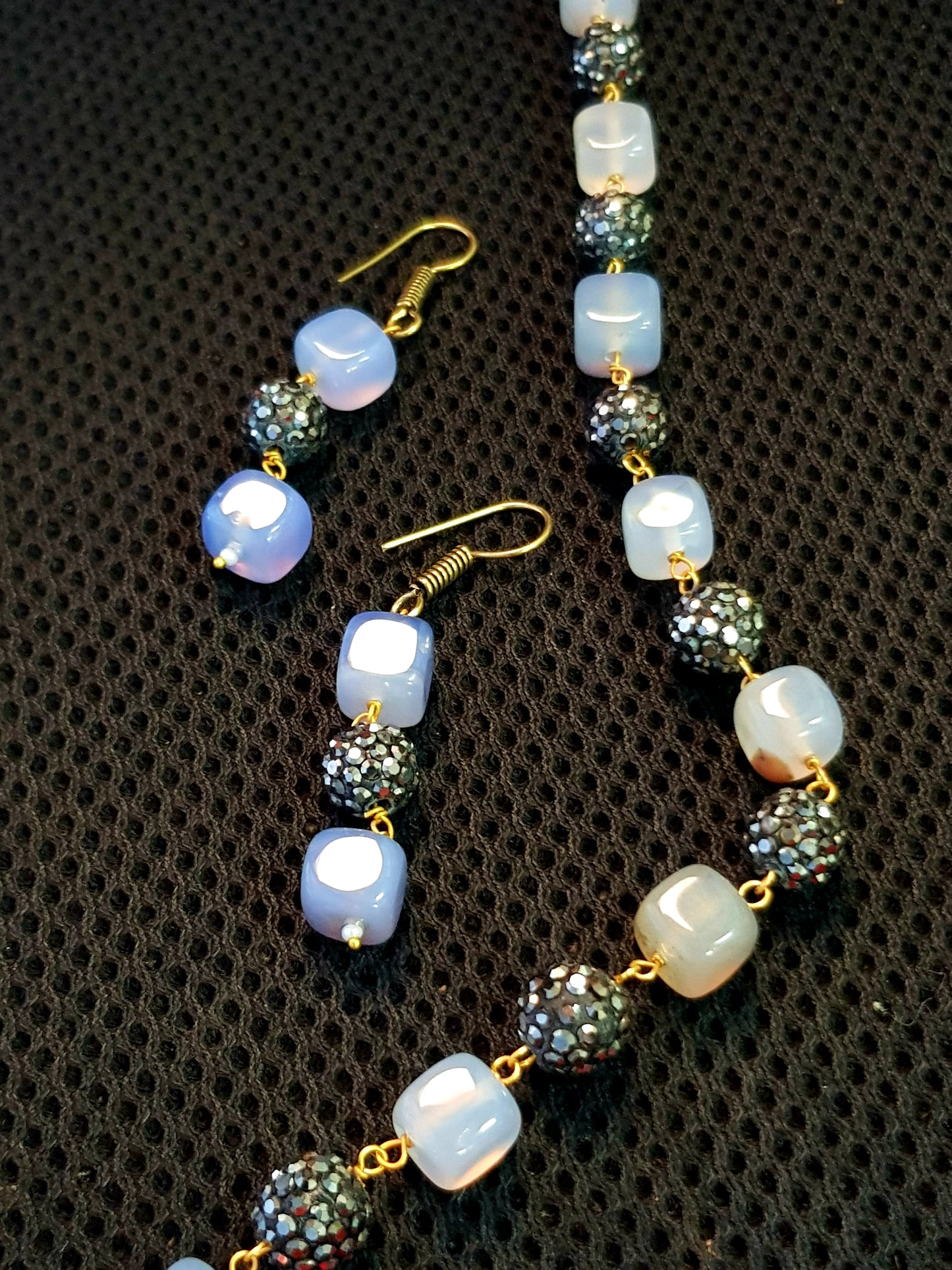 Set with black glittering metal beads coupled with square coloured stone.