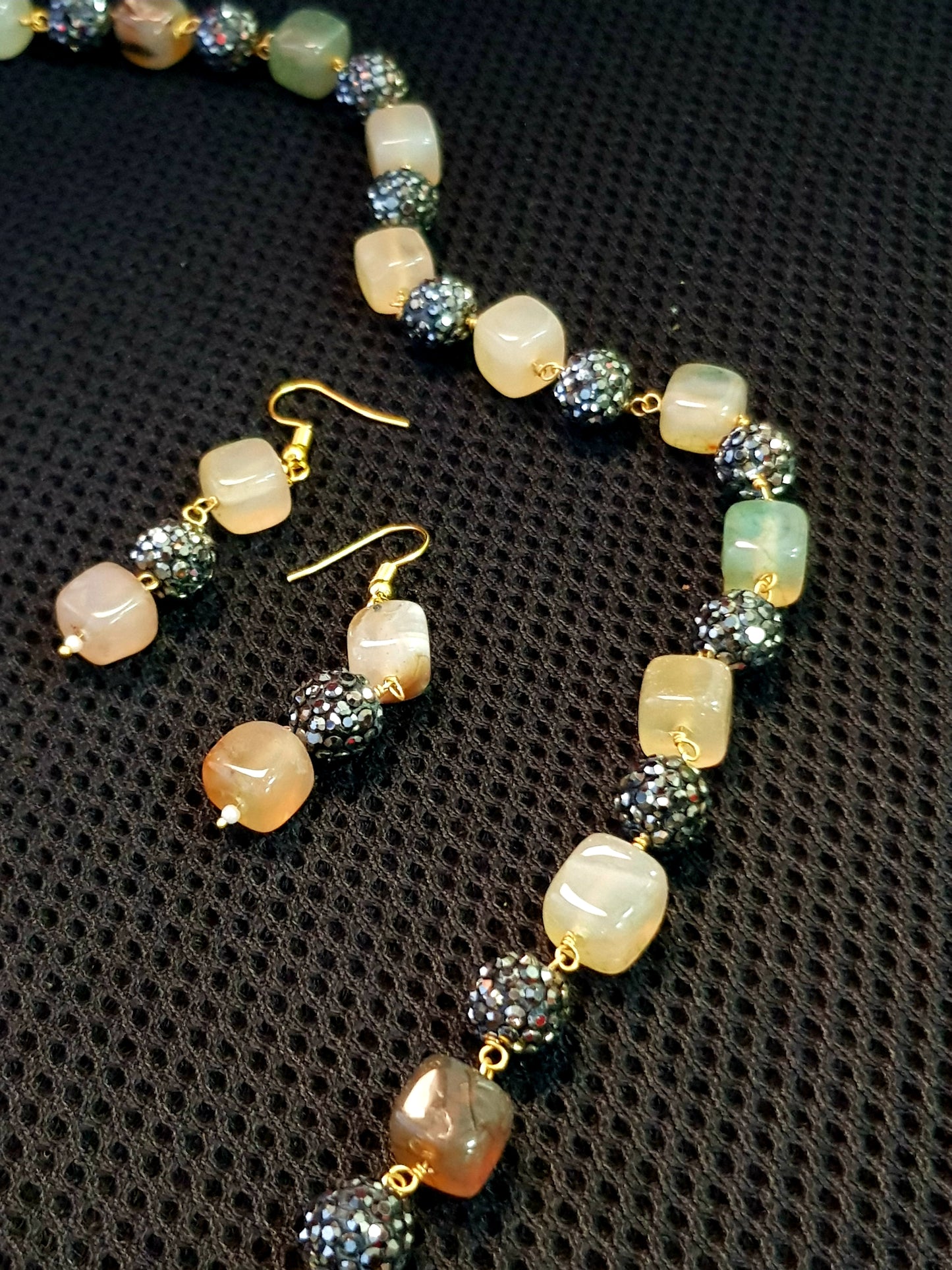 Set with black glittering metal beads coupled with square coloured stone.