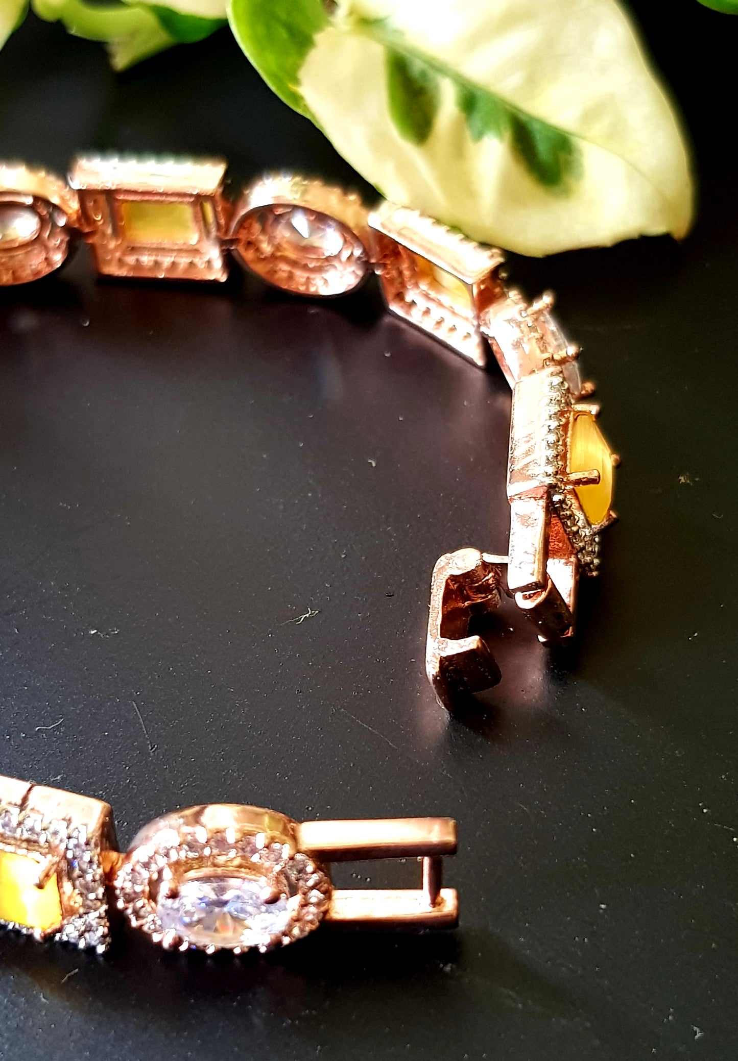 Platinum finish bracelet, square aqua/topaz stone surrounded by CZ interspaced with oval clear stone with CZ around