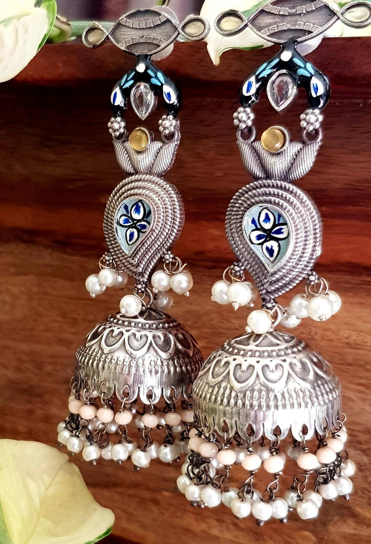 Silver finish jhumka (earrings) with handpainted paisely piece and studs, embellished with stones