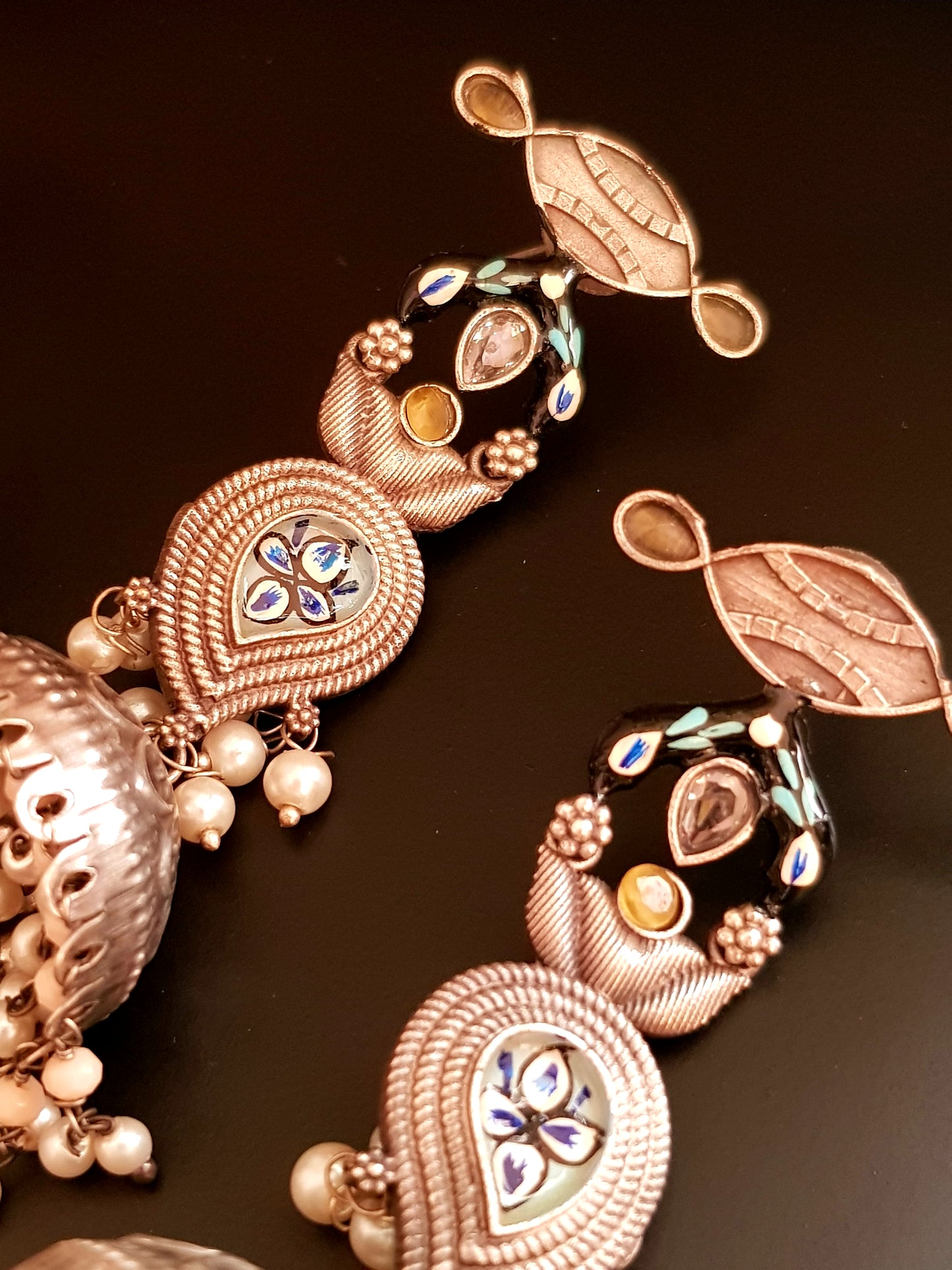 Silver finish jhumka (earrings) with handpainted paisely piece and studs, embellished with stones