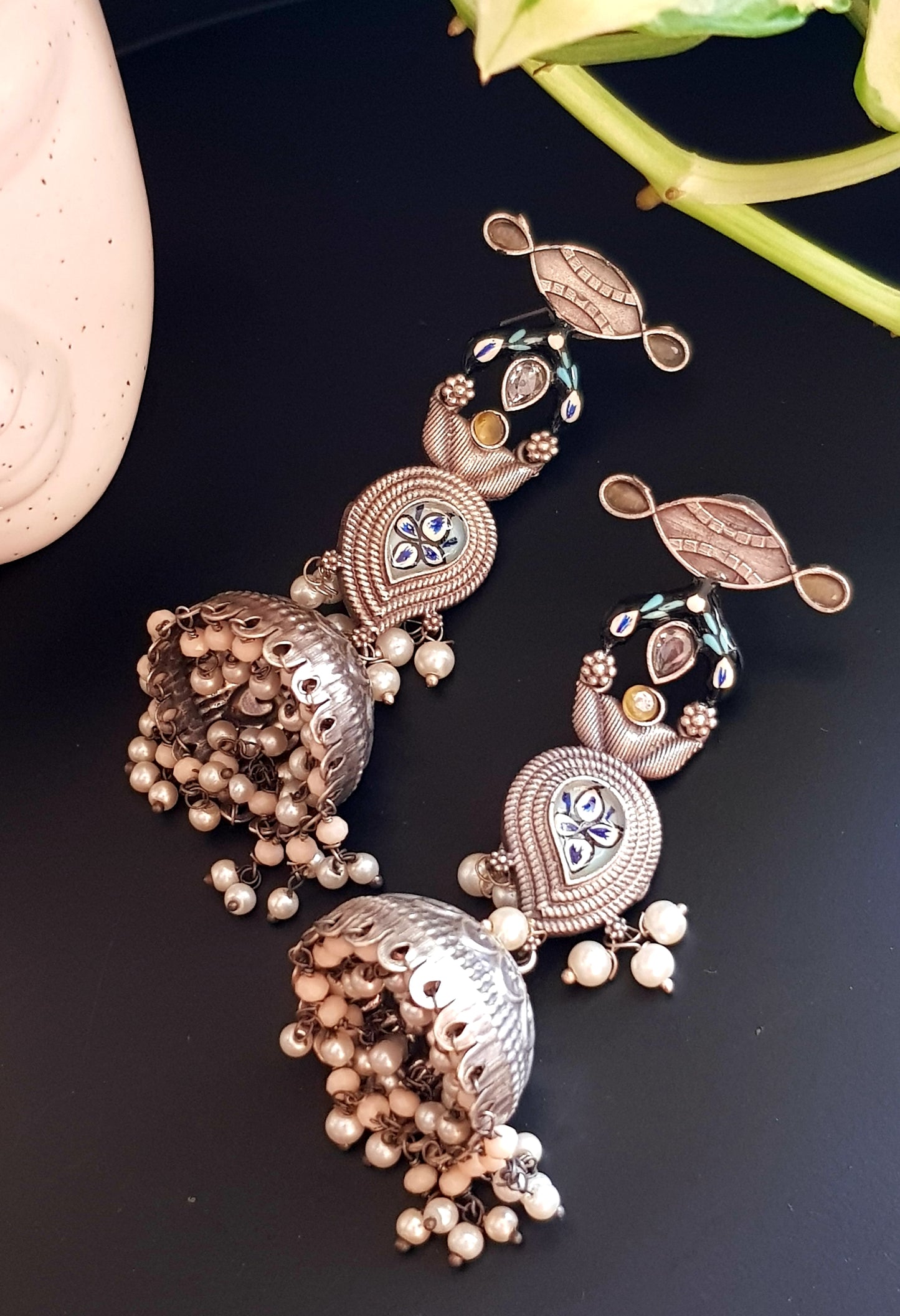 Silver finish jhumka (earrings) with handpainted paisely piece and studs, embellished with stones