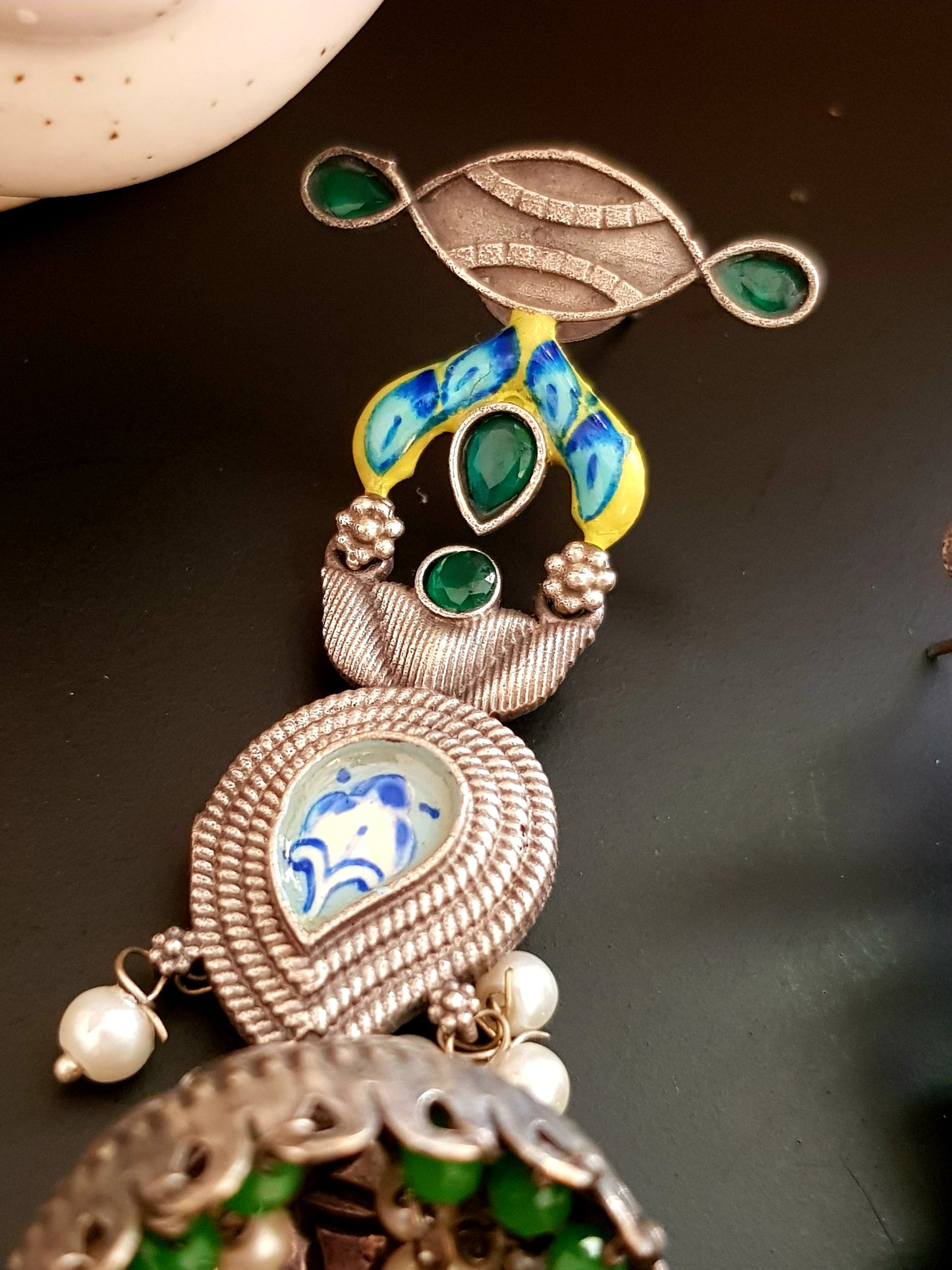 Silver finish jhumka (earrings) with handpainted paisely piece and studs, embellished with stones