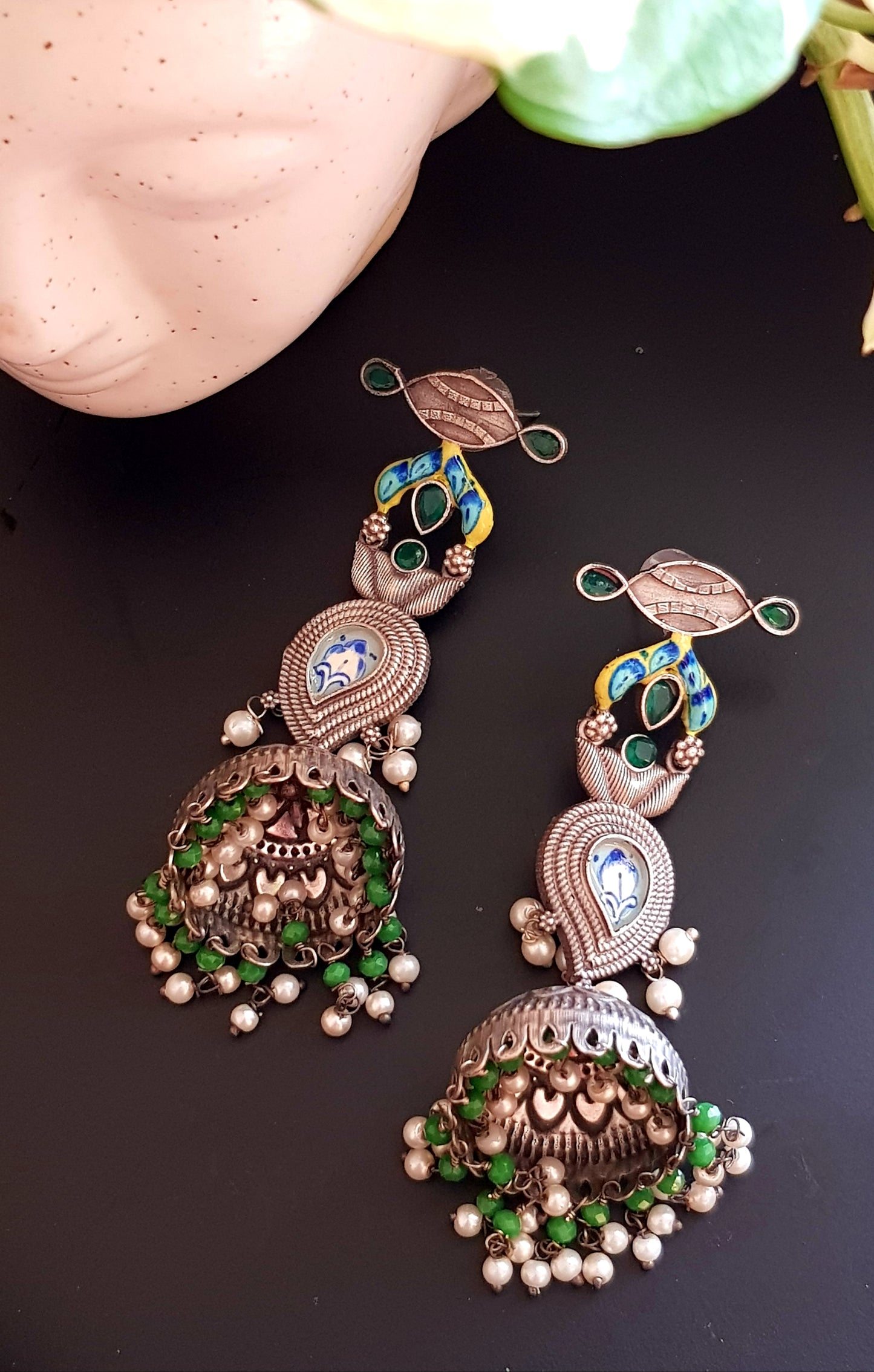 Silver finish jhumka (earrings) with handpainted paisely piece and studs, embellished with stones