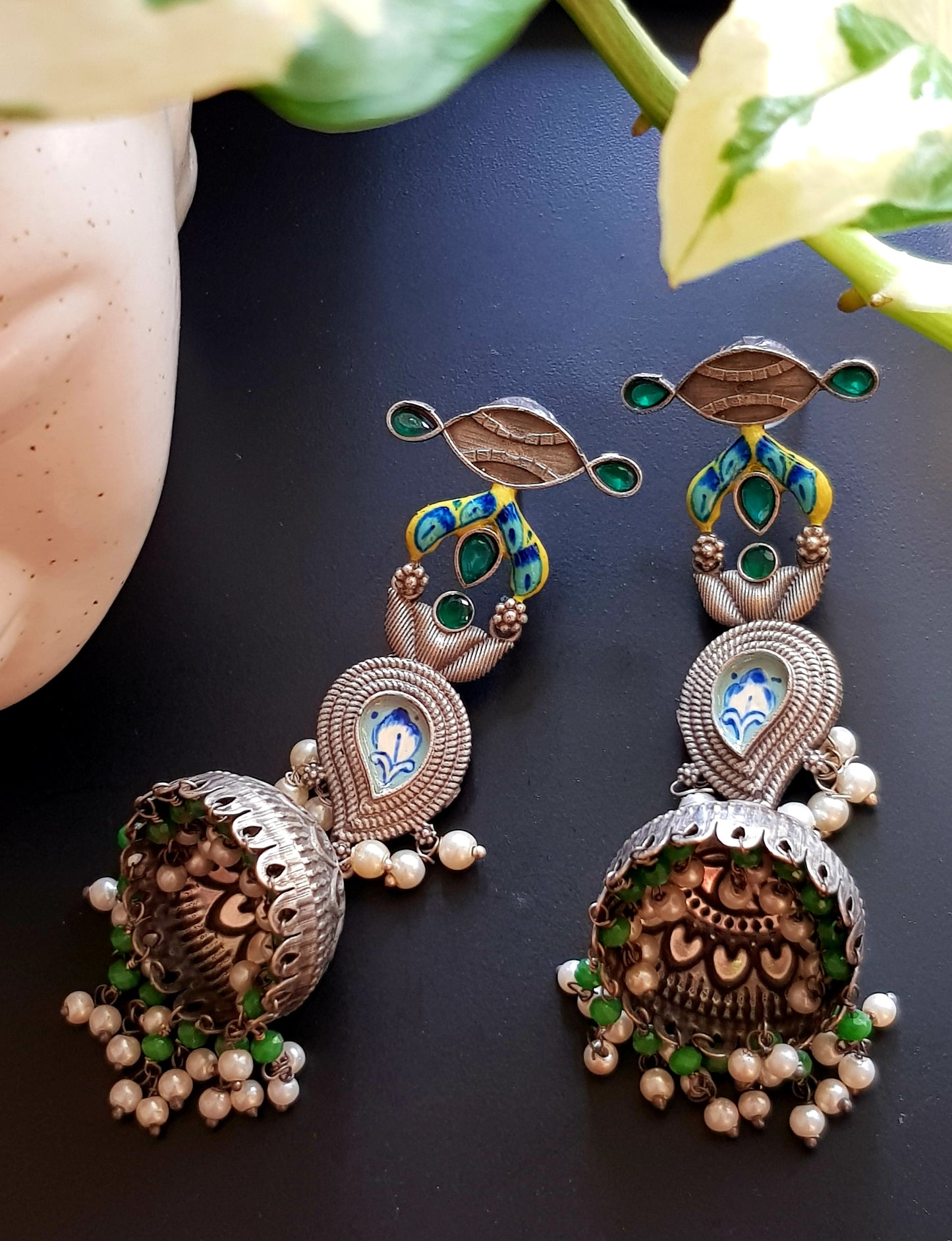 Silver finish jhumka (earrings) with handpainted paisely piece and studs, embellished with stones