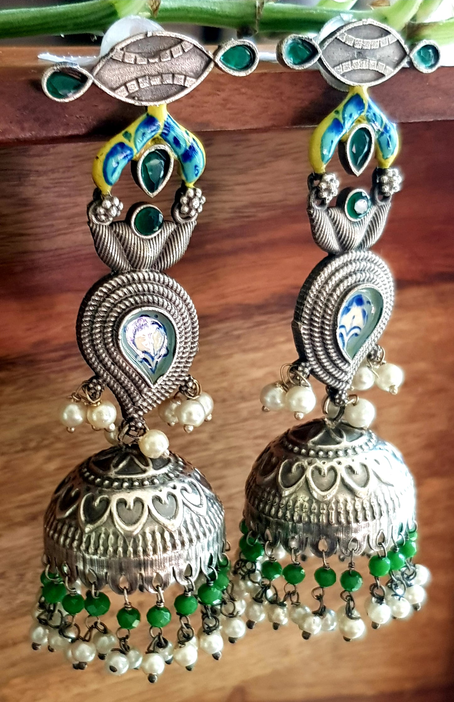 Silver finish jhumka (earrings) with handpainted paisely piece and studs, embellished with stones