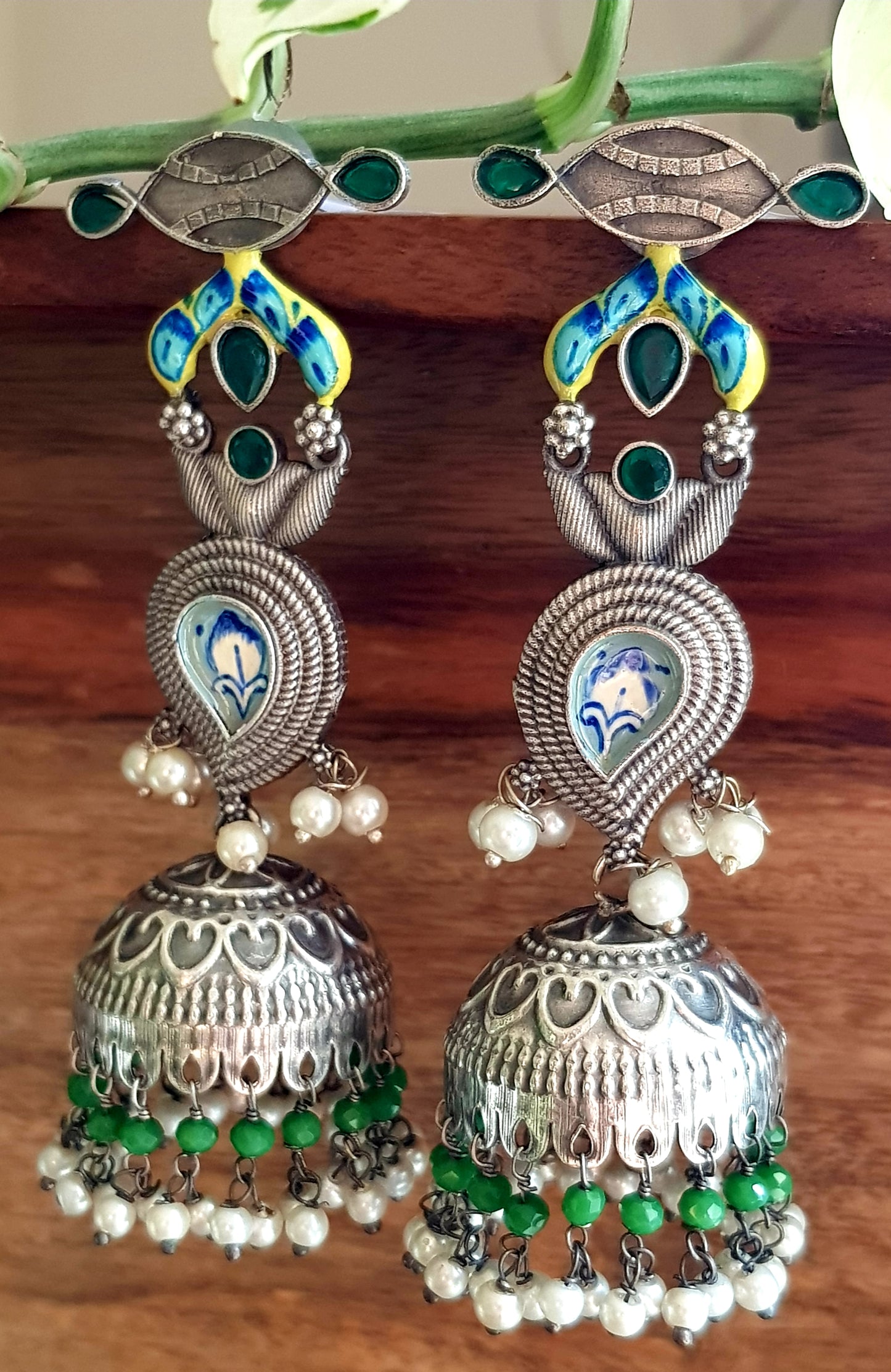 Silver finish jhumka (earrings) with handpainted paisely piece and studs, embellished with stones