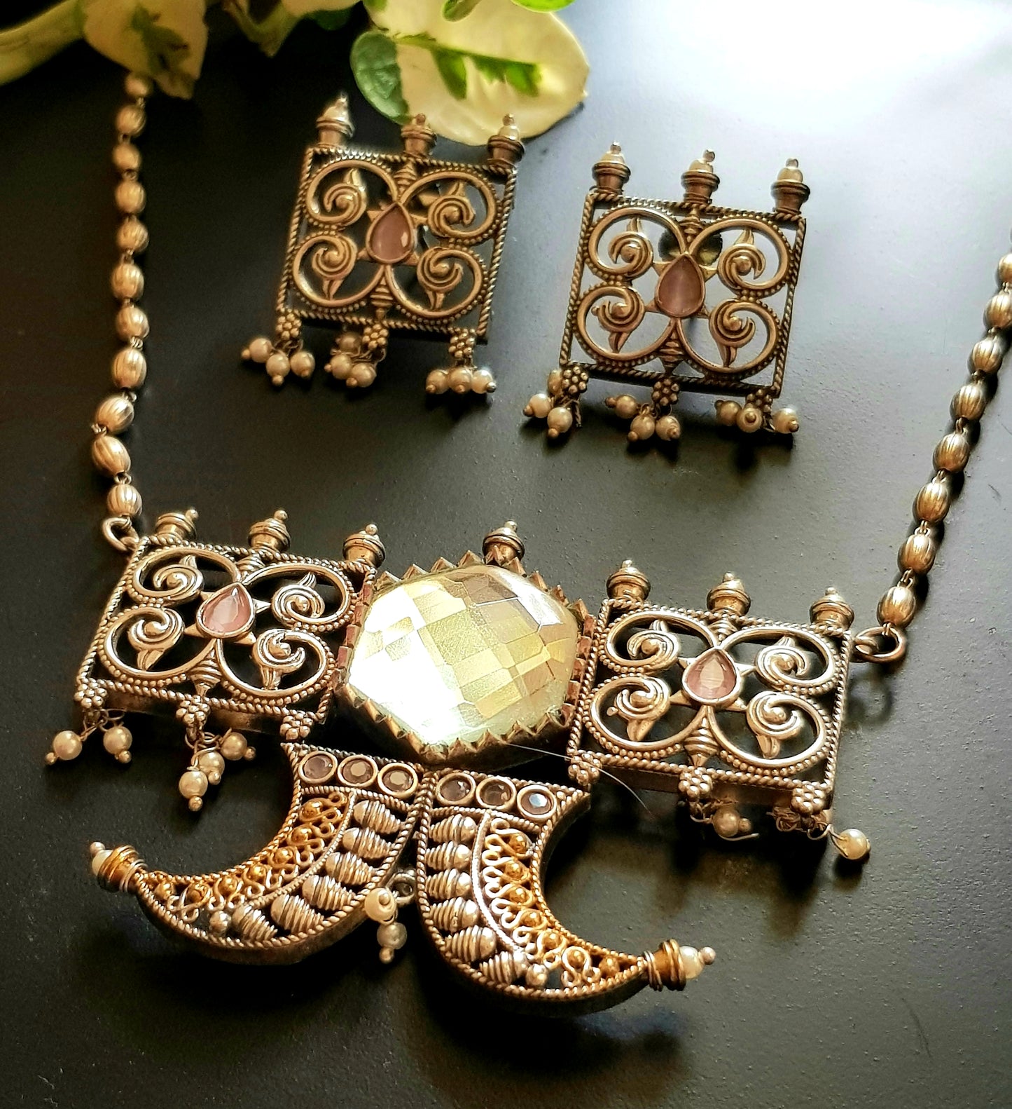 Dual tone set with two curved knives below circular clear stone and square jaali pieces, matching studs (earrings)