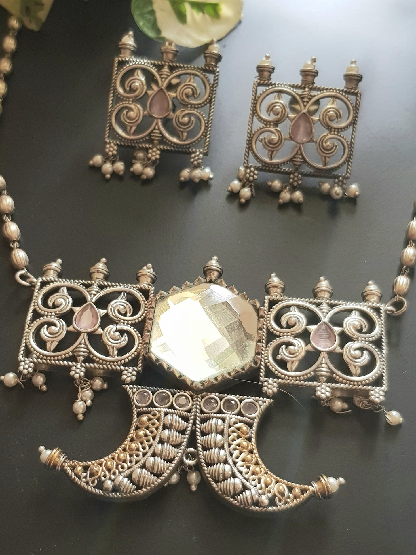 Dual tone set with two curved knives below circular clear stone and square jaali pieces, matching studs (earrings)