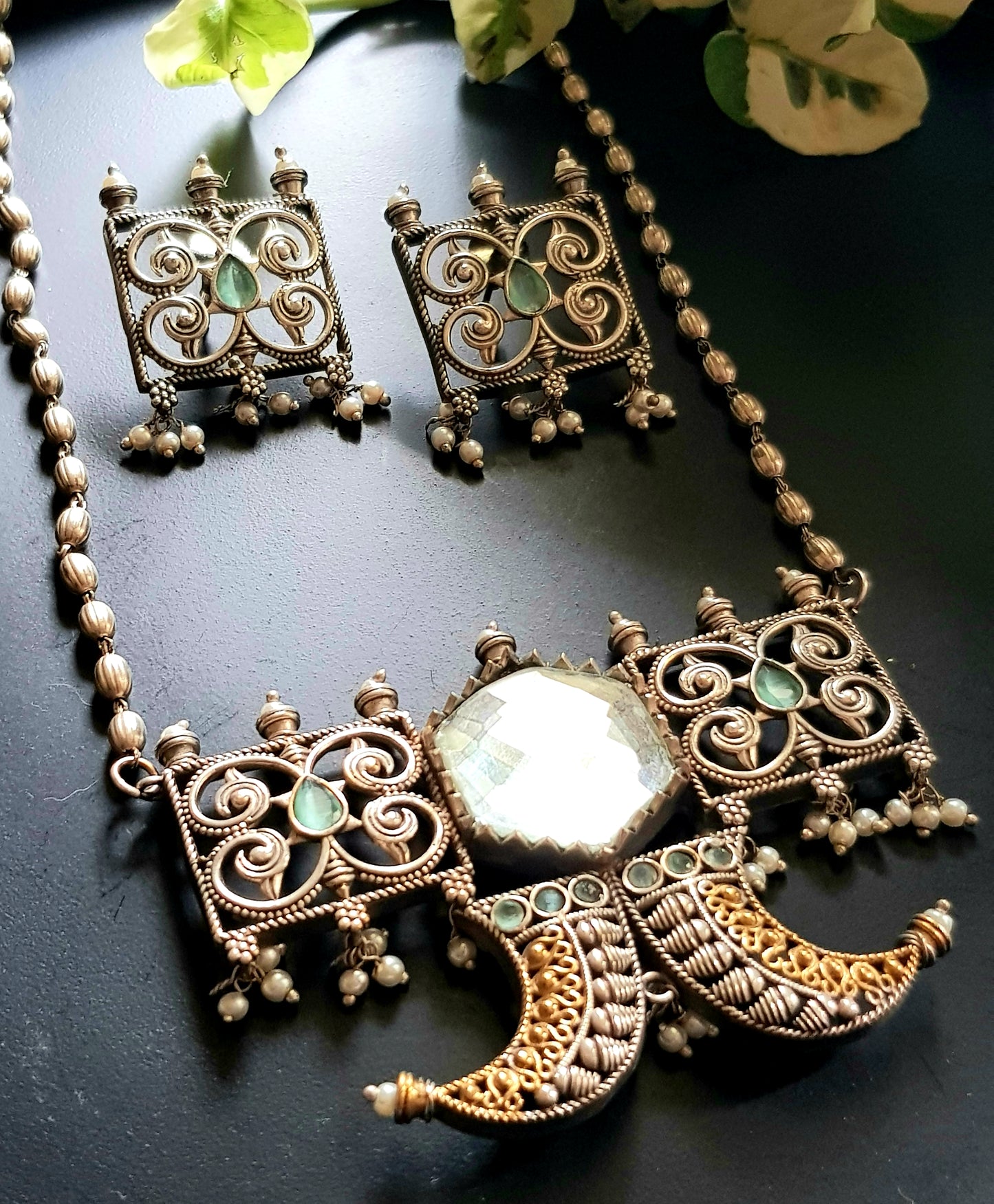 Dual tone set with two curved knives below circular clear stone and square jaali pieces, matching studs (earrings)