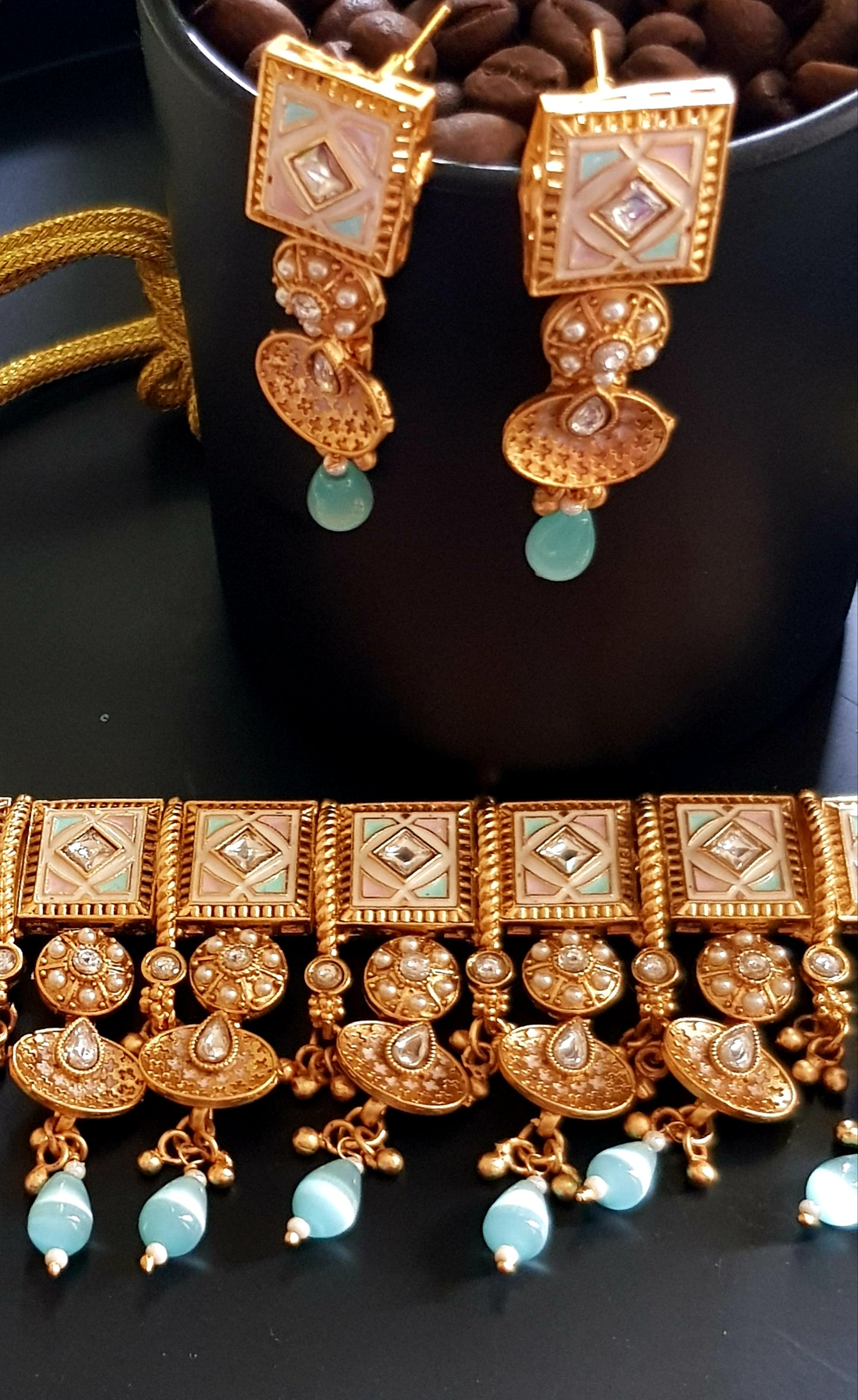 Gold finish choker set in pastel pink and blue enamel work on square tikdas, matching long earrings