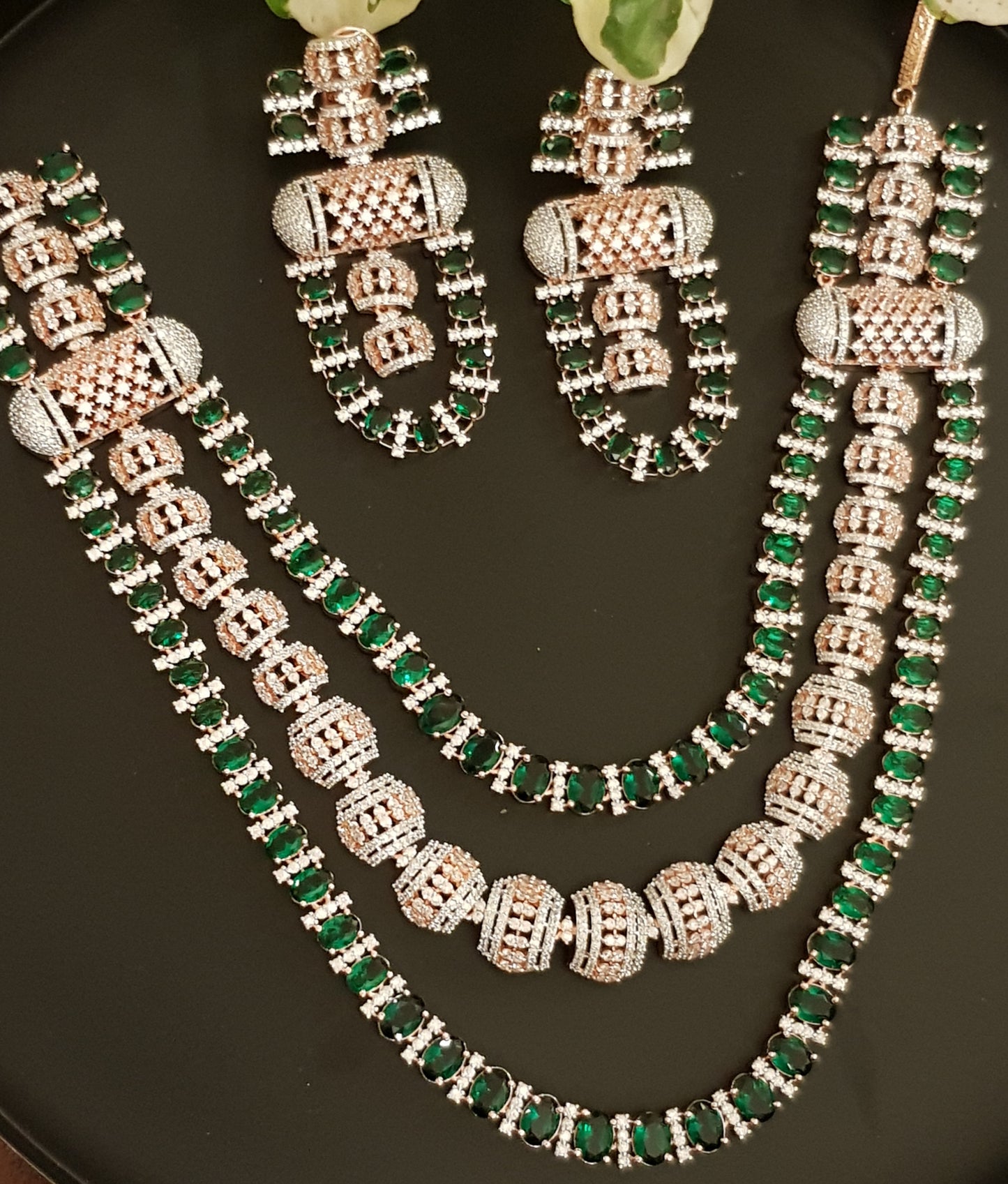 Rose gold finish set, triple strand necklace with 'dholna' design in CZ and emerald, matching earrings