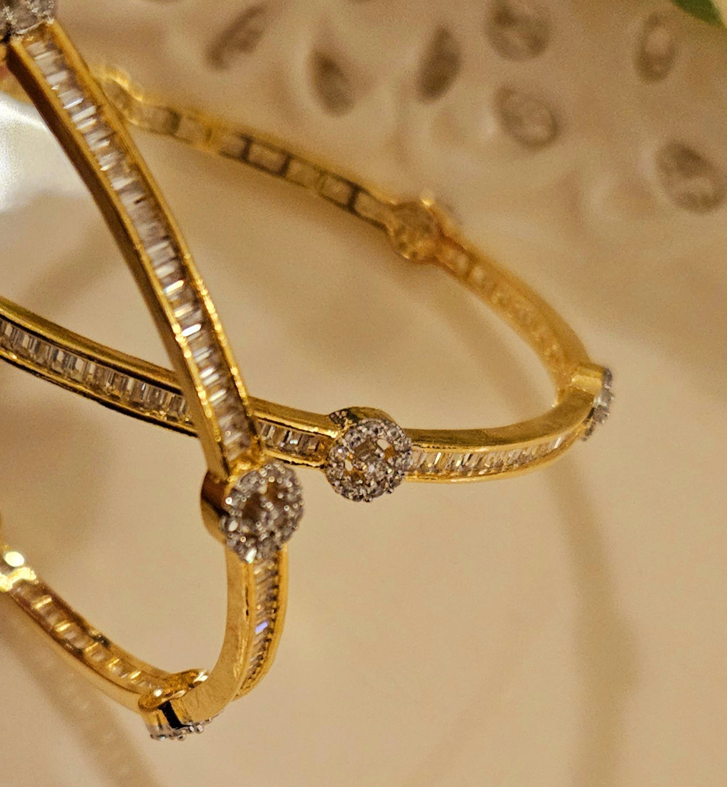 Gold finish sleek bangles with small cylindrical crystal and CZ flower design (2 pcs)