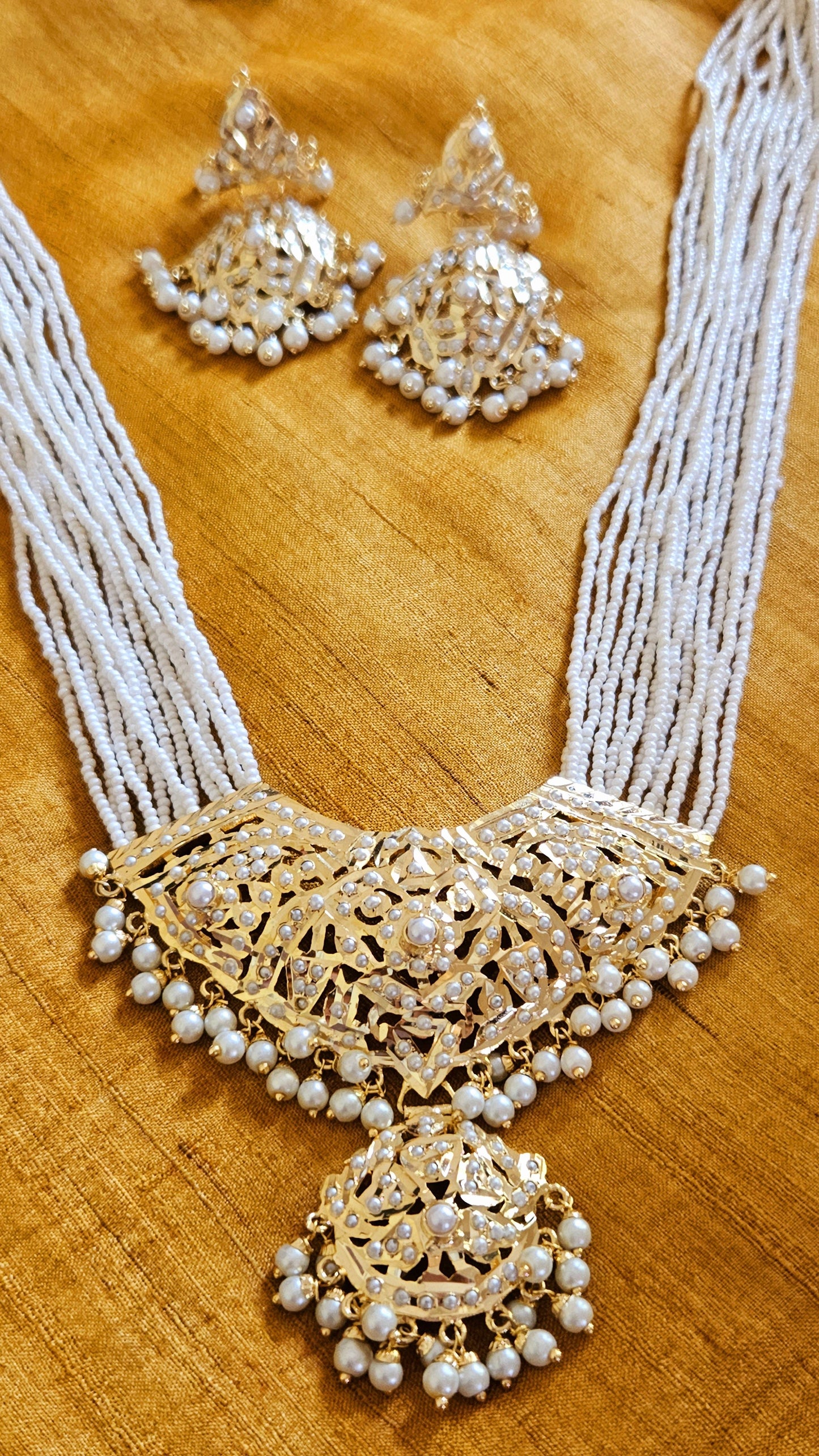 'Virtuous white' gold finish jadau set with navratan/pearl inlaid long necklace and matching earrings