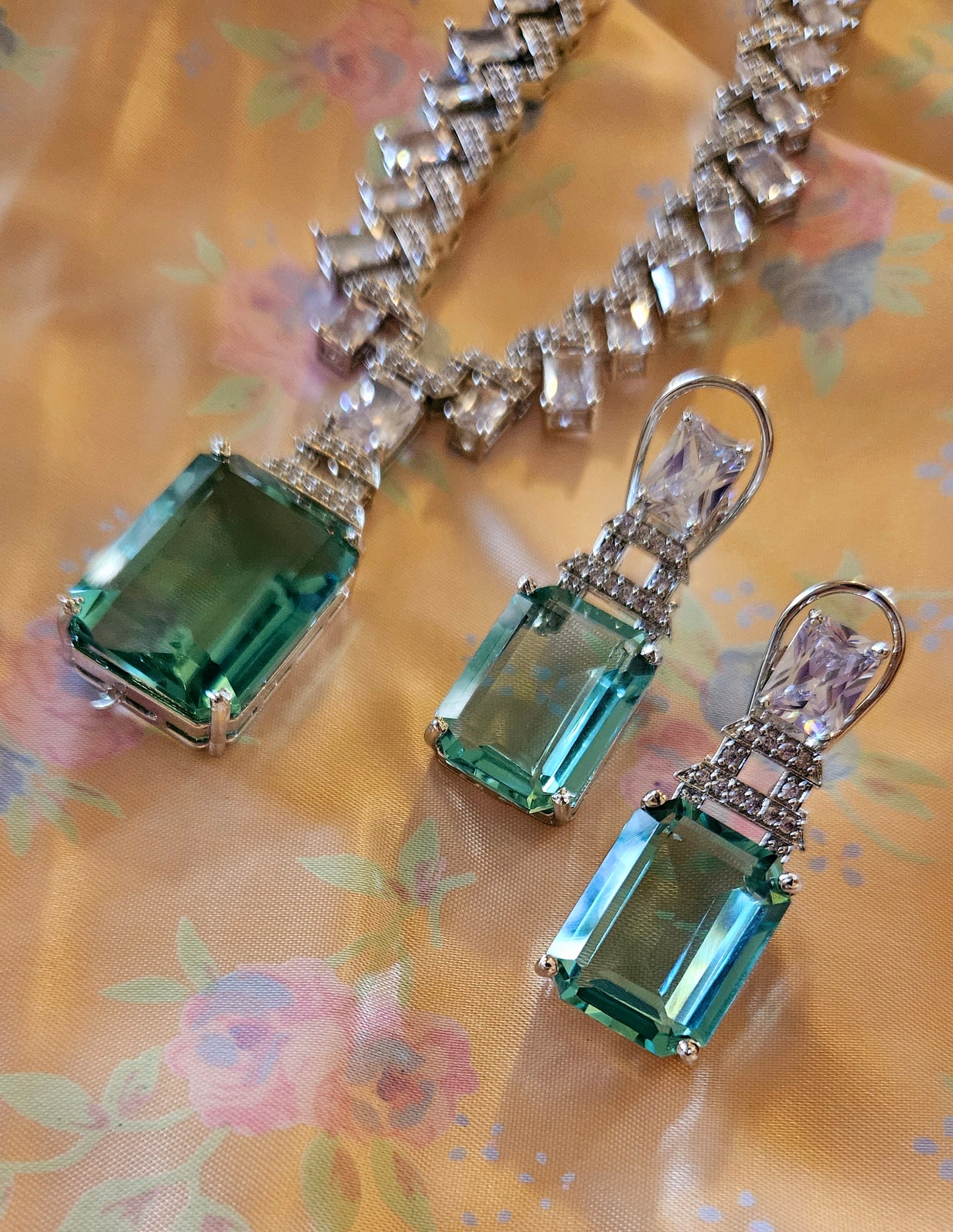 Platinum finish set with pale pink/mint green pendant on zig-zag pattern neutral colour CZ necklace, matching earrings