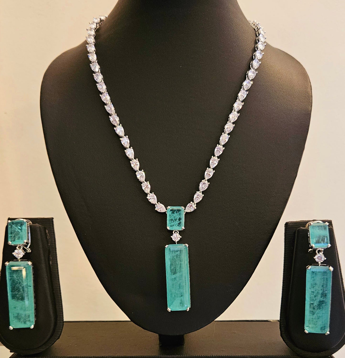 Platinum finish set with long mint green stone pendant in CZ single layer strand, matching earrings