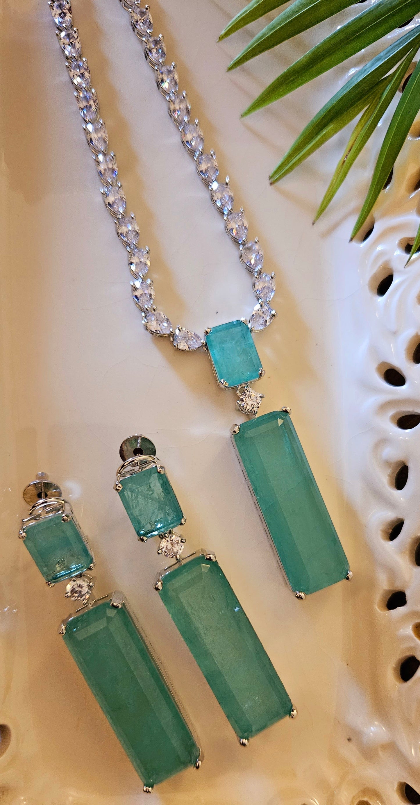 Platinum finish set with long mint green stone pendant in CZ single layer strand, matching earrings